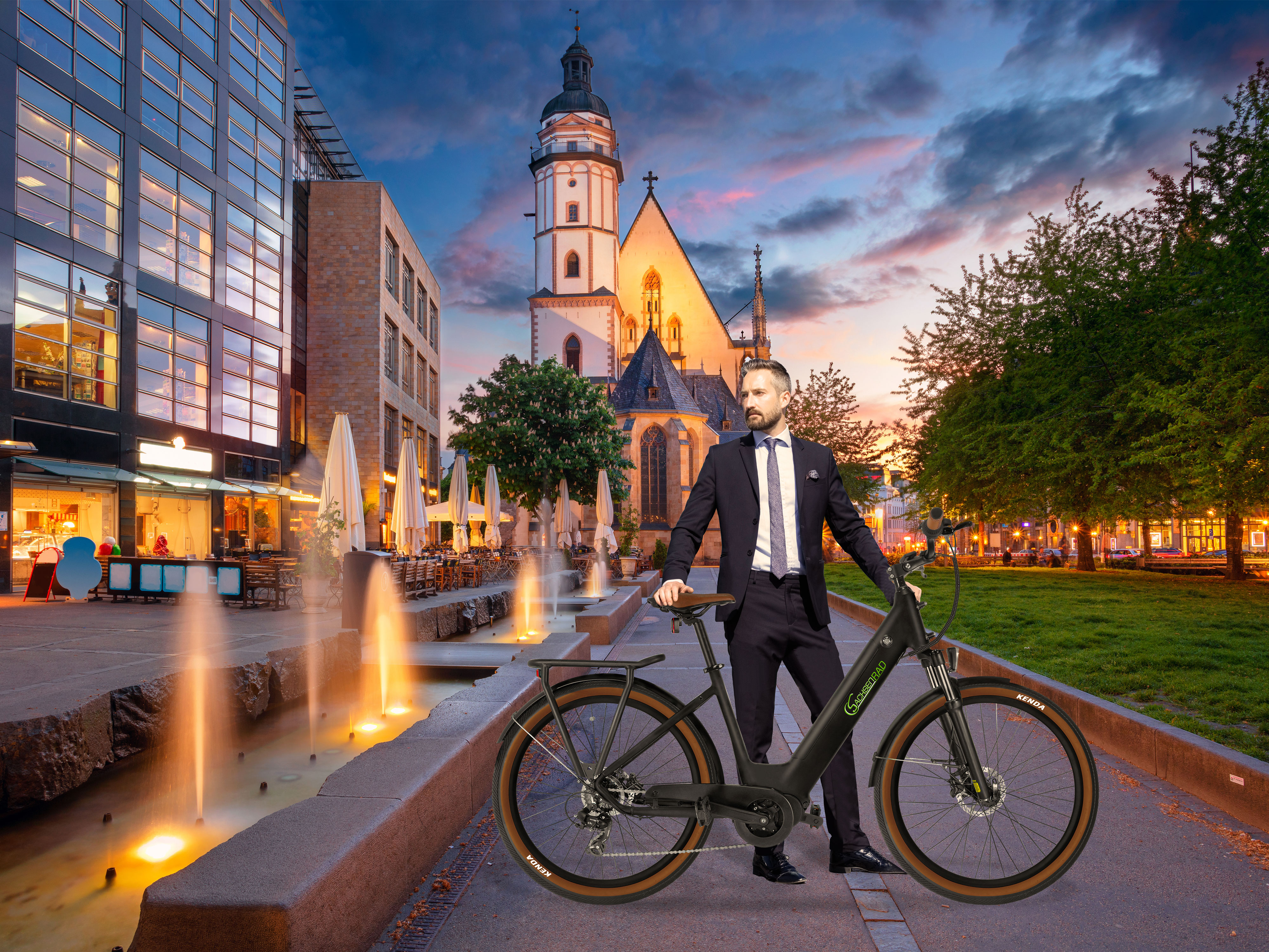 Man staat met een fiets voor een stadslandschap met een fontein.