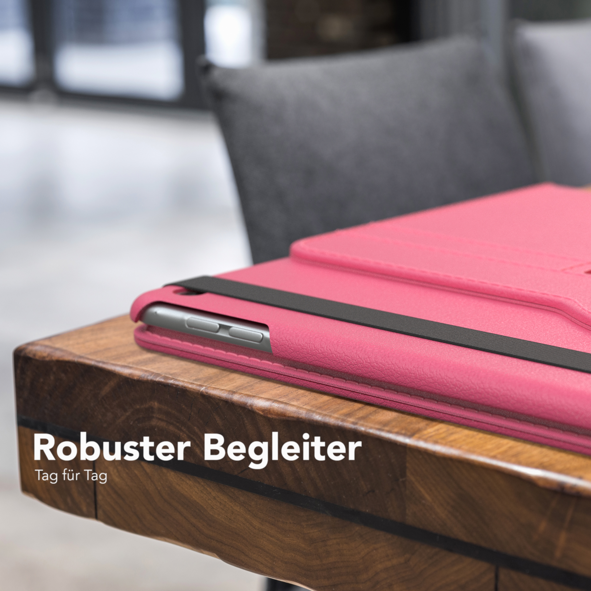 Rosa Tablethülle mit schwarzem Gummiband. Holztisch mit Text: "Robuster Begleiter".