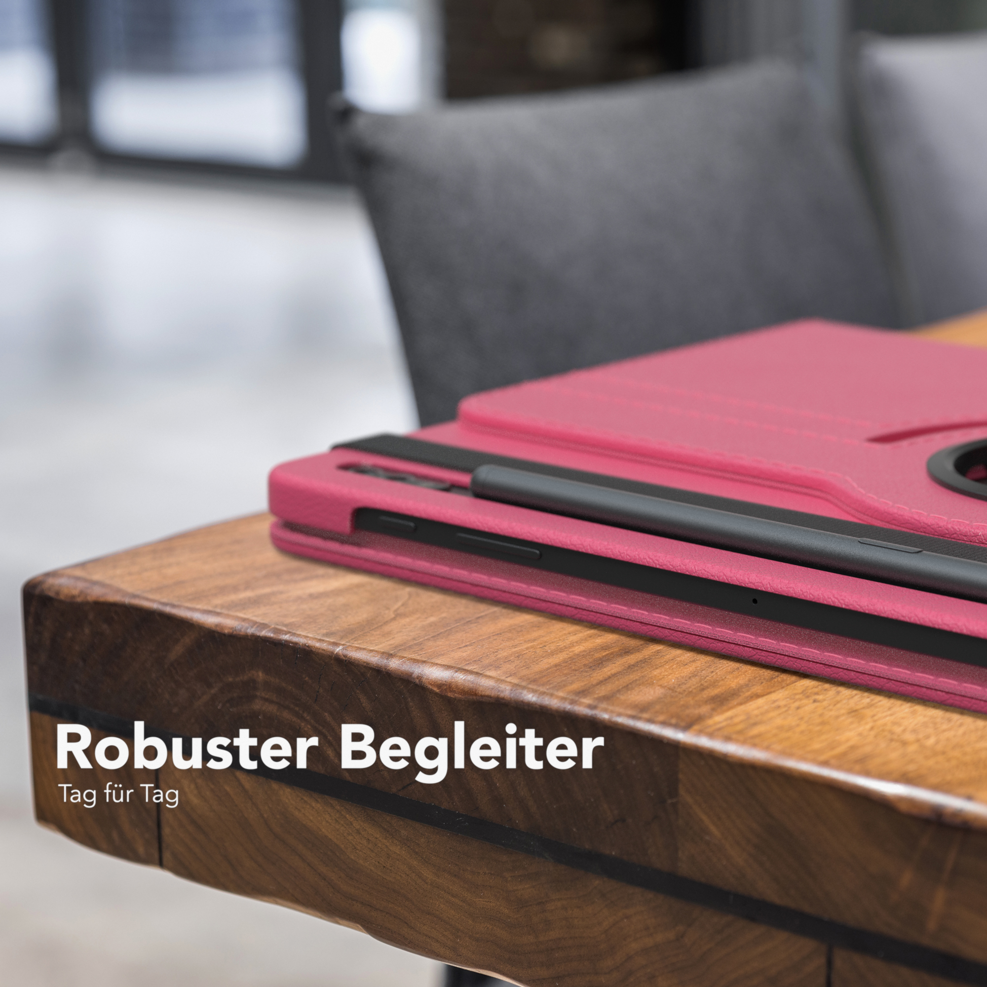 Tablet in pinker Hülle auf Holztisch. Schwarzer Stift liegt oben, darunter Text.