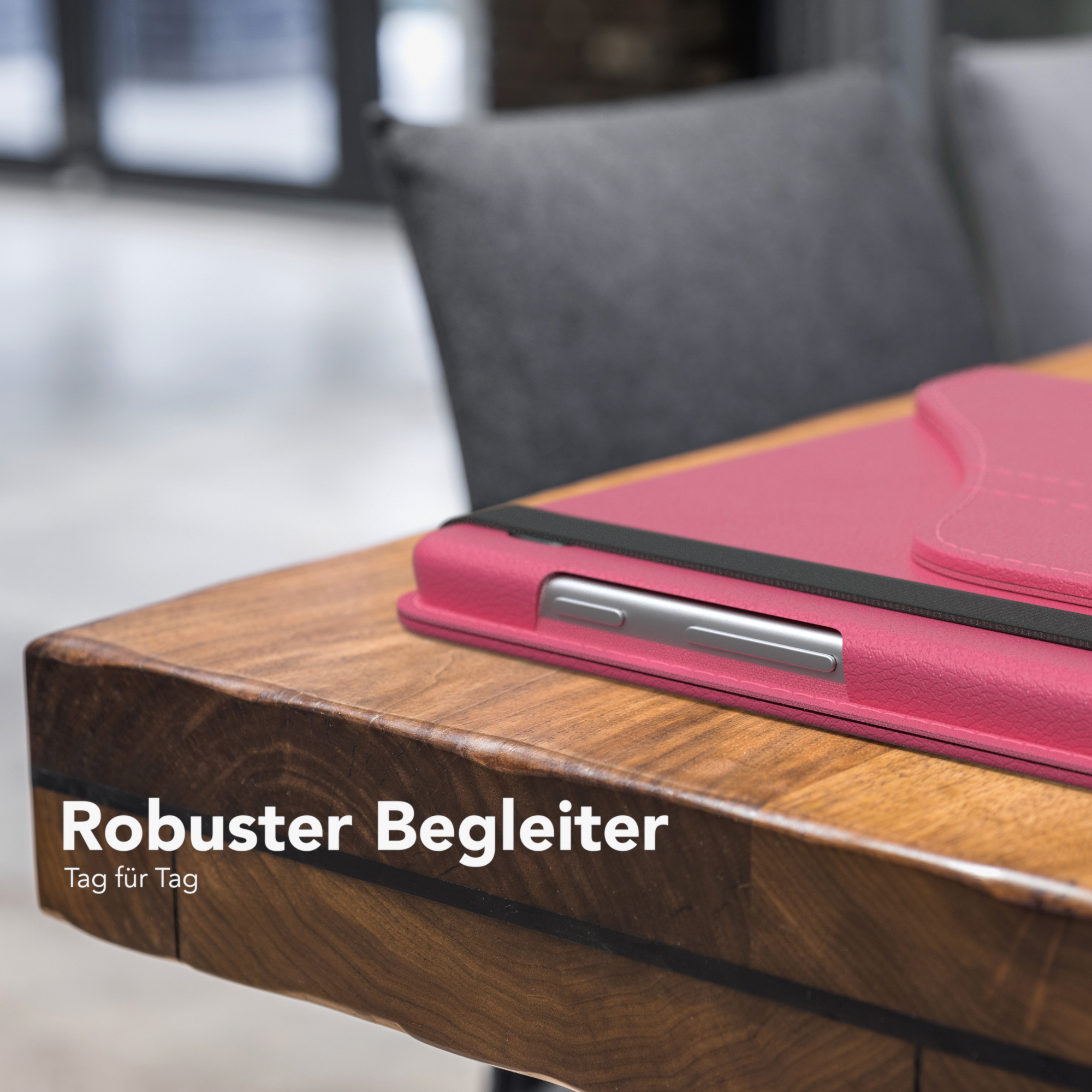 Tablet in rosa Hülle auf einem Holztisch.