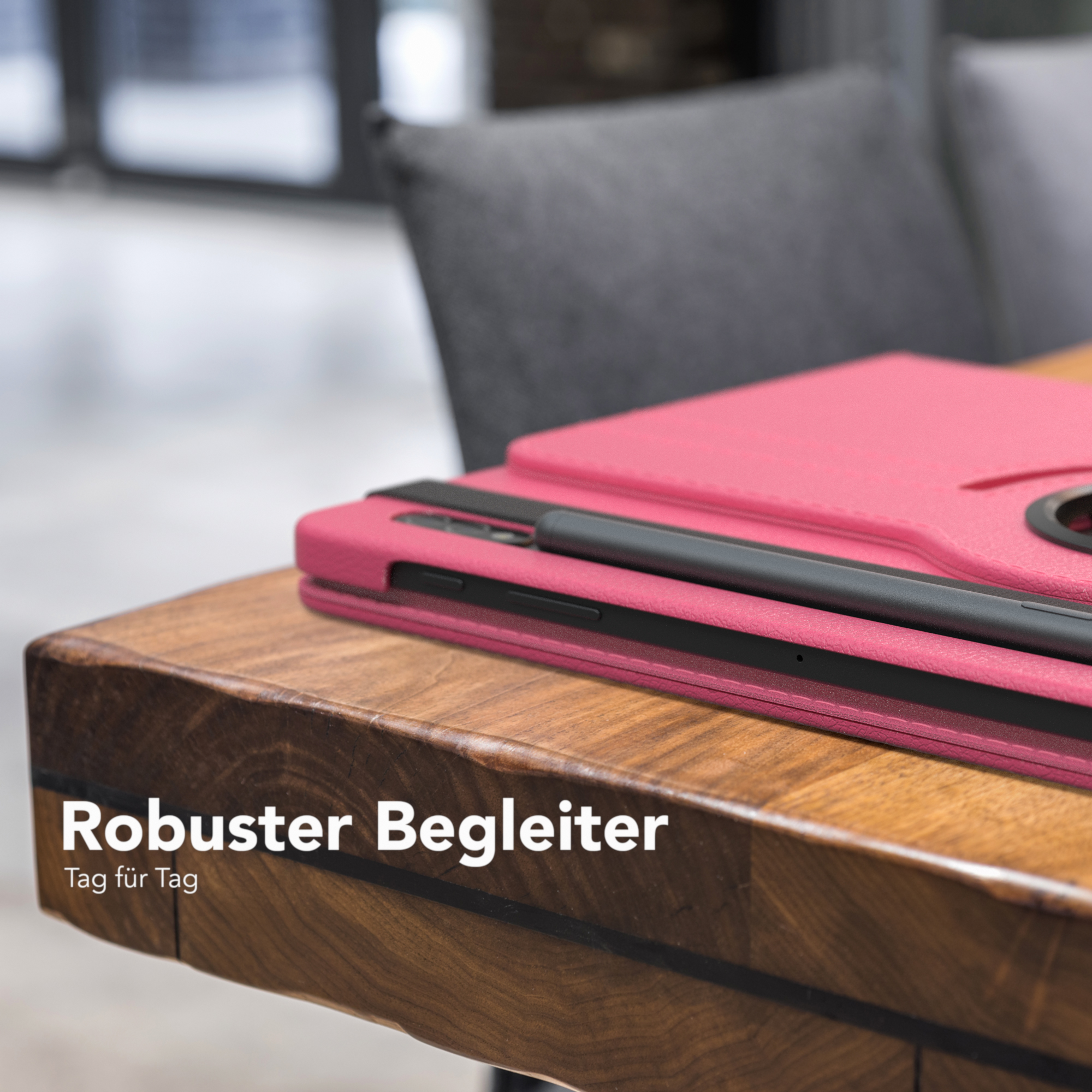 Rosa Tablet-Hülle auf Holztisch. Grauer Stuhl im Hintergrund.
