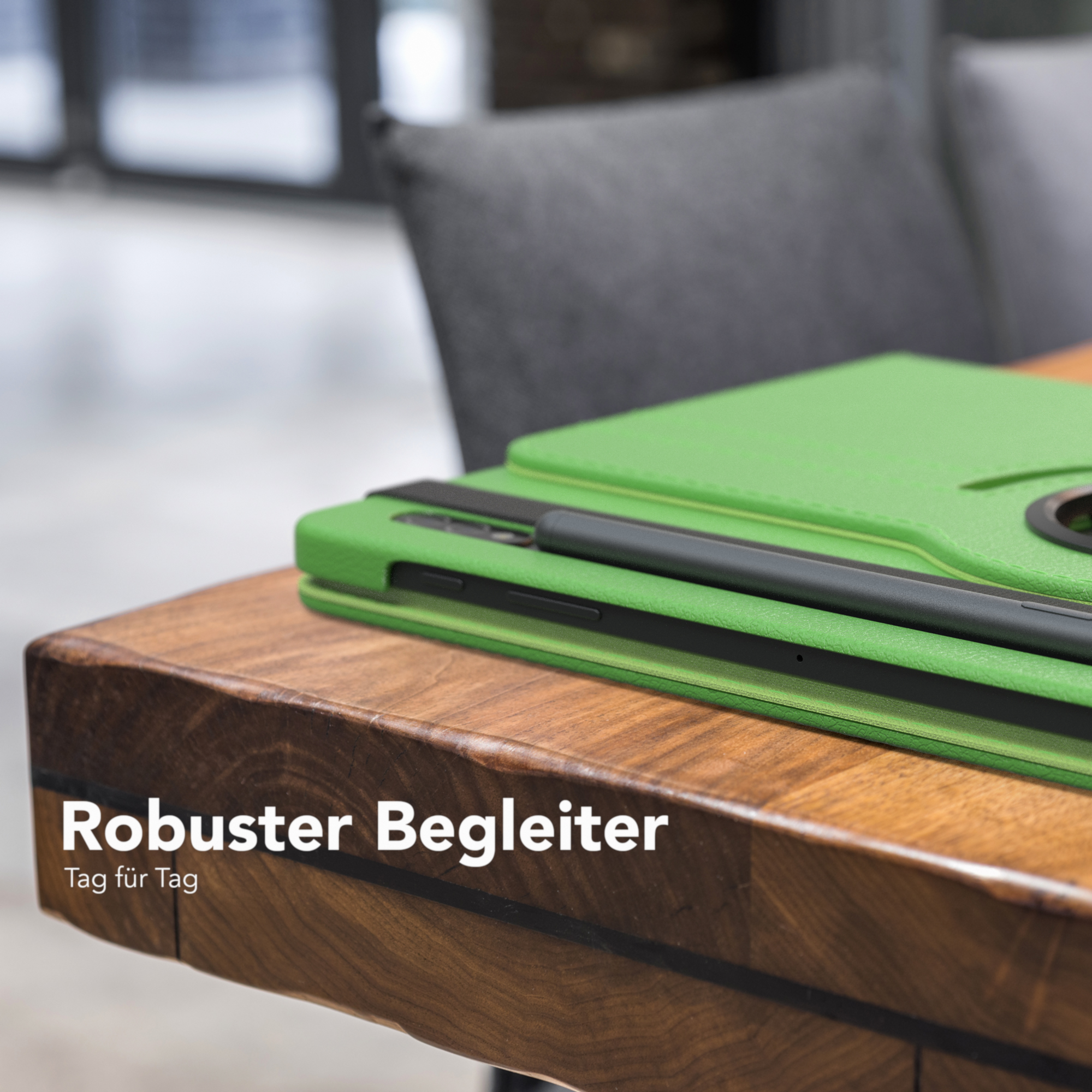 Grüne Tablethülle mit Stift auf einem Holztisch. Die Hülle ist teilweise geöffnet, das Tablet sichtbar.