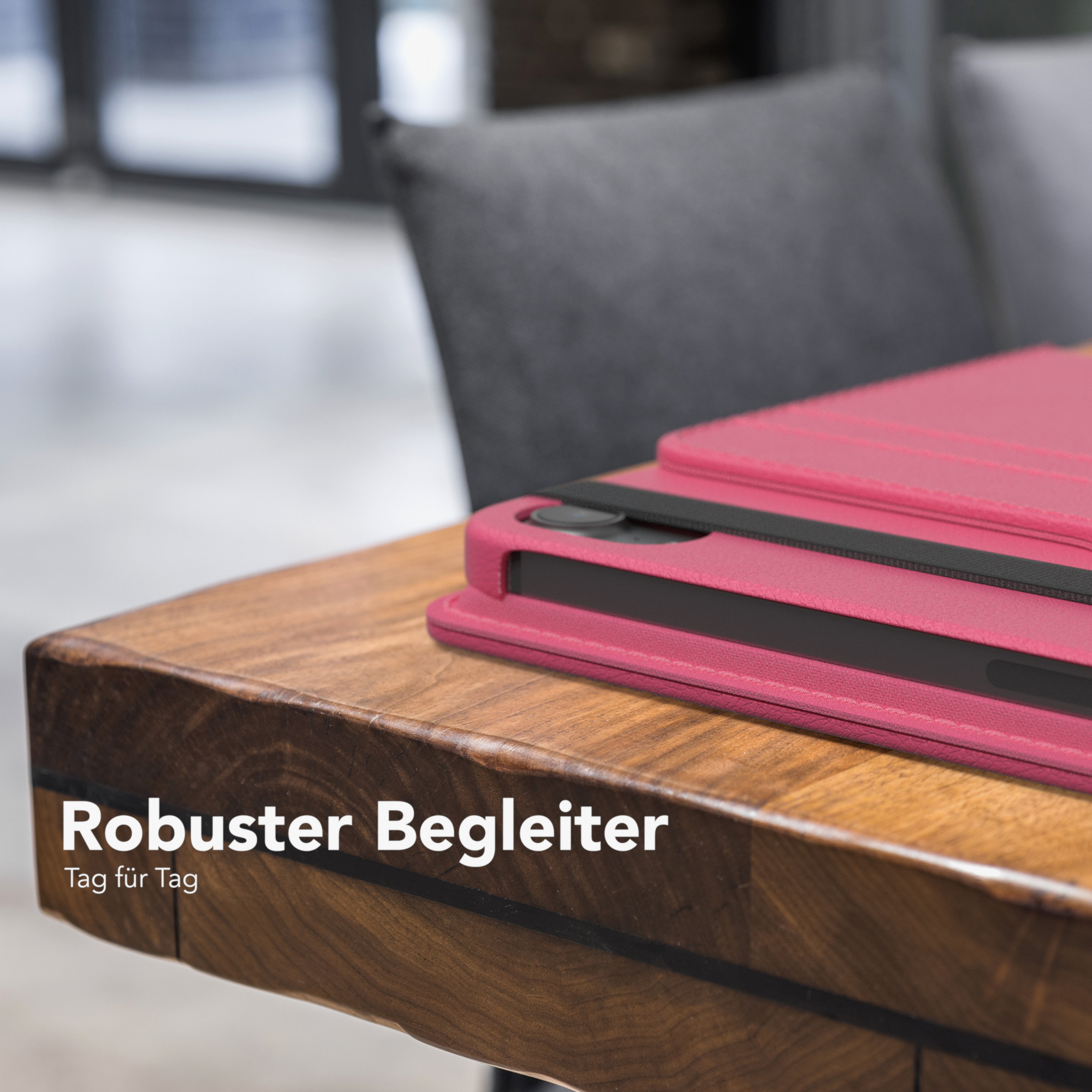 Eine pinke Tablethülle auf einem Holztisch. Der Text „Robuster Begleiter“ ist weiß.