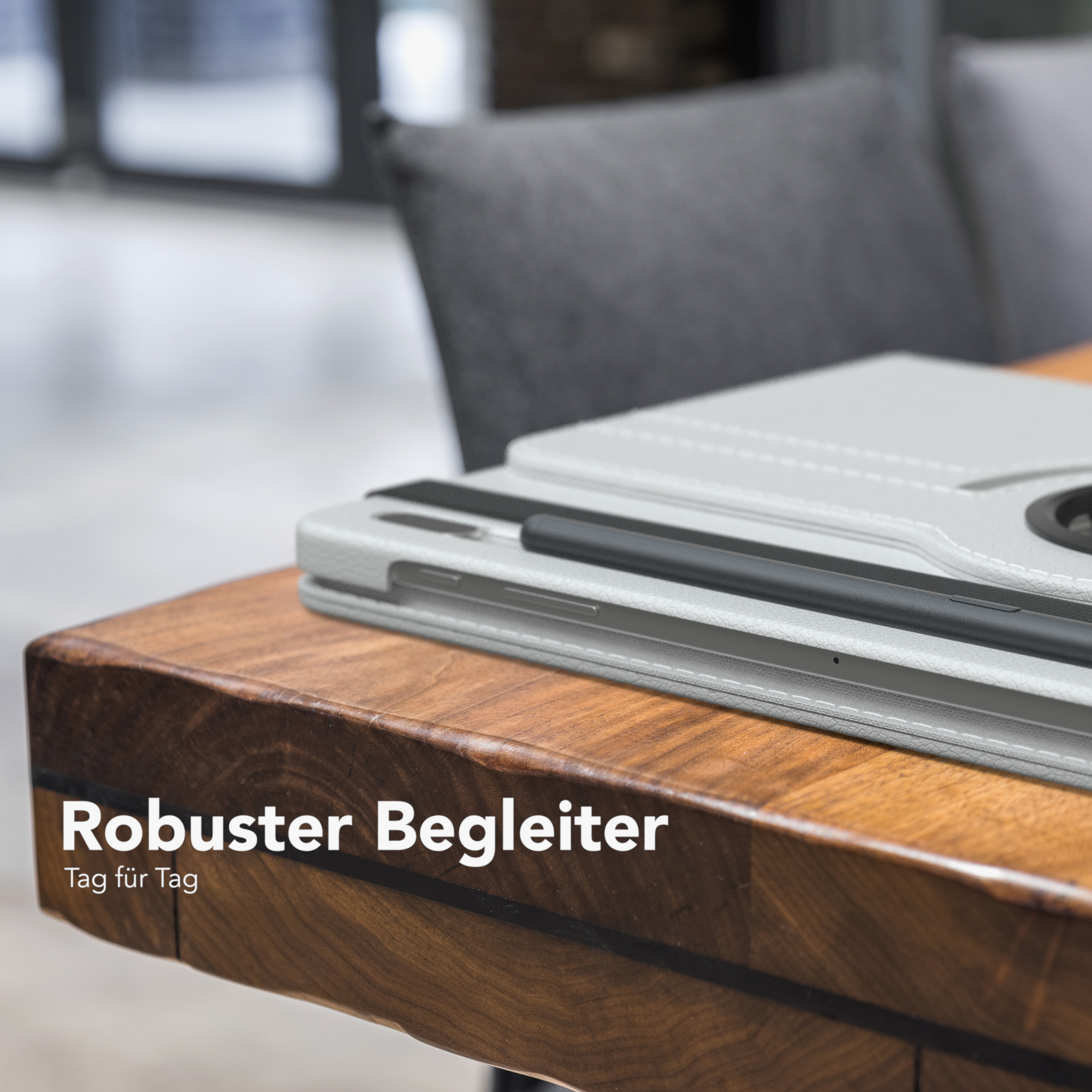 Tablet in grauer Hülle auf einem Holztisch. Text: „Robuster Begleiter Tag für Tag“.