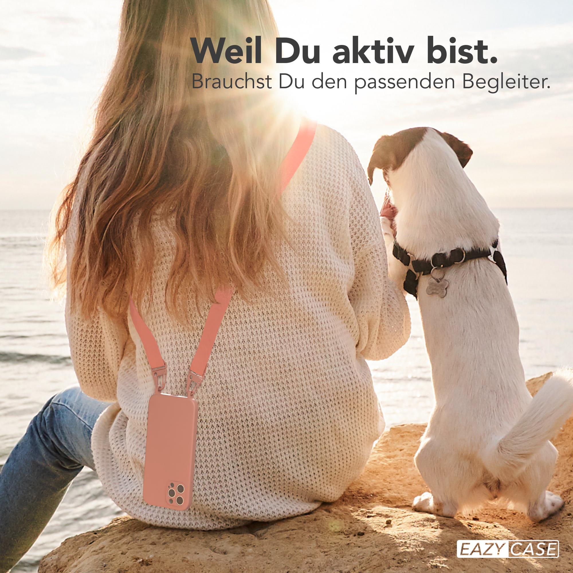 Frau mit Hund und Telefon. Frau mit Telefon in der Hand, die eine Handykette trägt, und ein Hund. Szene im Freien.