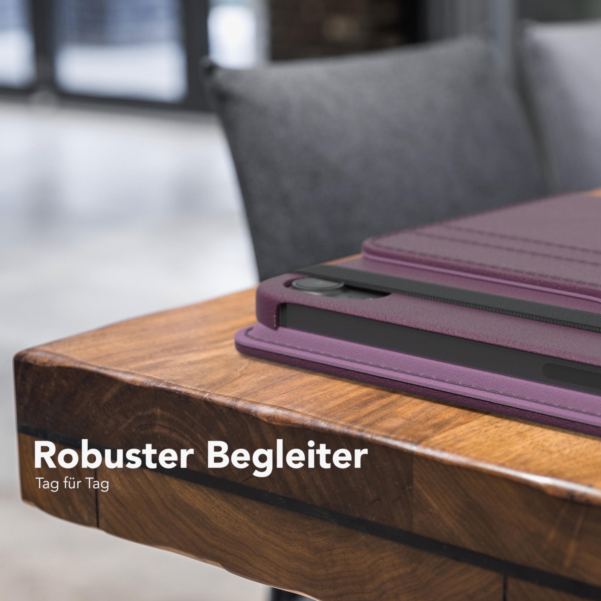 Ein Tablet in lilafarbener Hülle auf einem Holztisch. Text: 'Robuster Begleiter'.