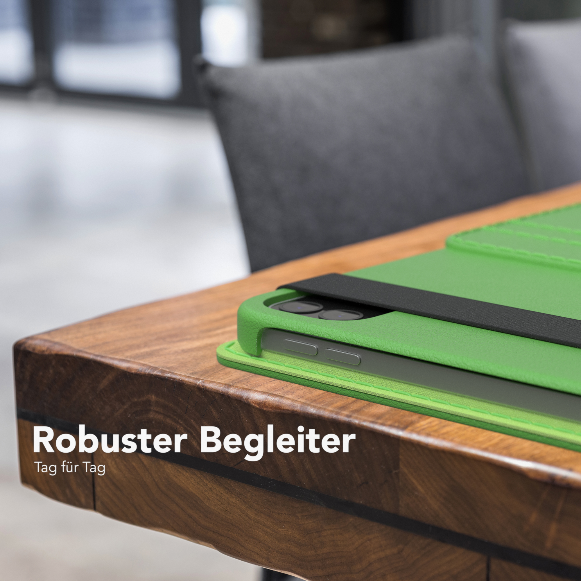 Grüne Tablet-Hülle auf einem Holztisch. Der Text auf dem Bild lautet 'Robuster Begleiter'.