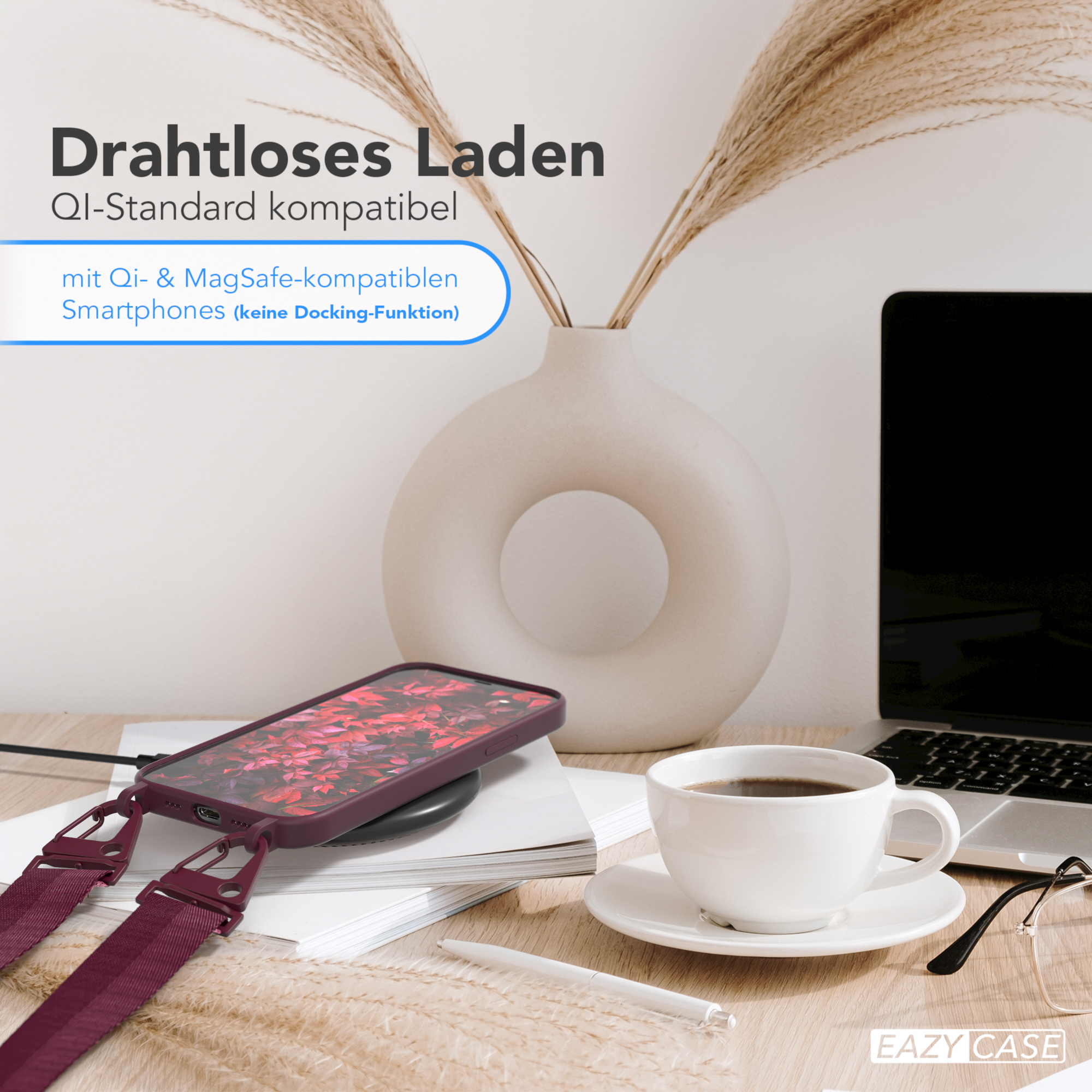 Ein Telefon auf einem kabellosen Ladegerät, neben einer Kaffeetasse und einer Vase mit Pflanzen, auf einem Holztisch.