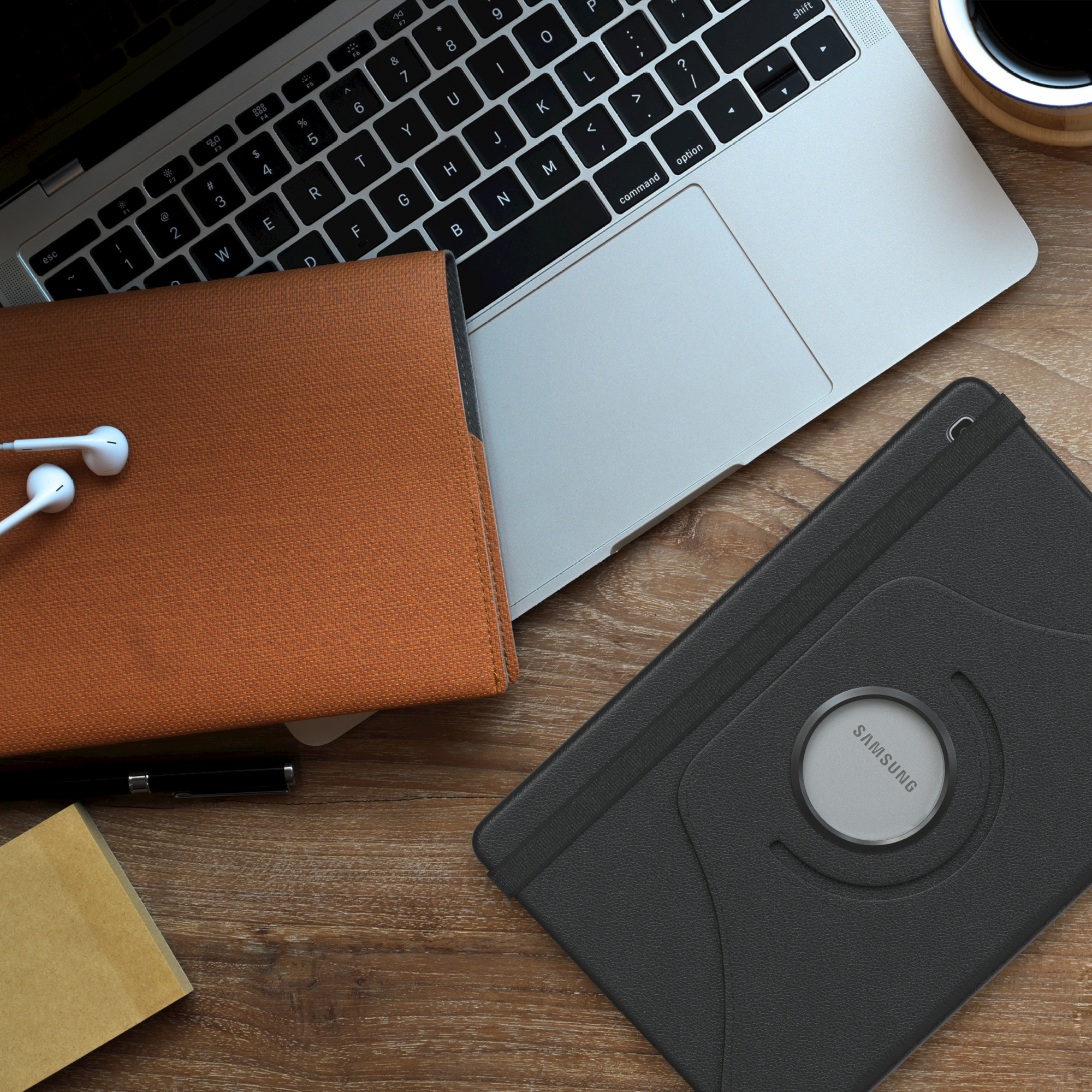 Laptop, Tablet und Zubehör auf einem Holztisch. Kaffeetasse. Kopfhörer.