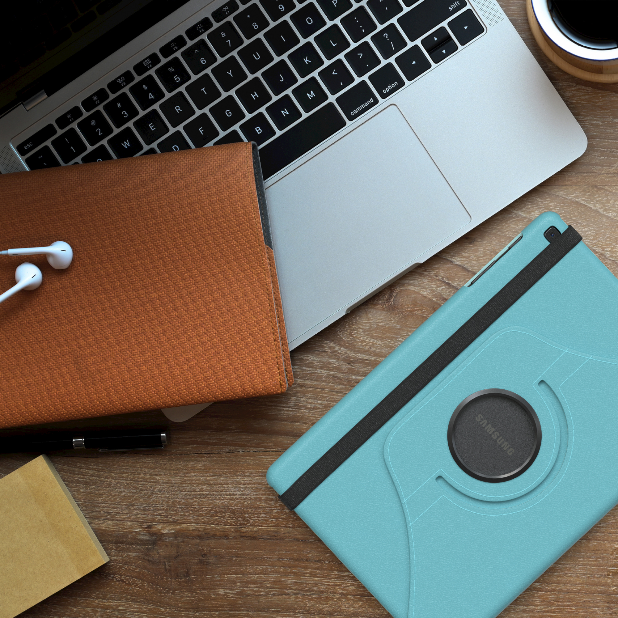 Tablethülle, Laptop, Kaffeetasse und Kopfhörer auf einem Holztisch. Draufsicht.