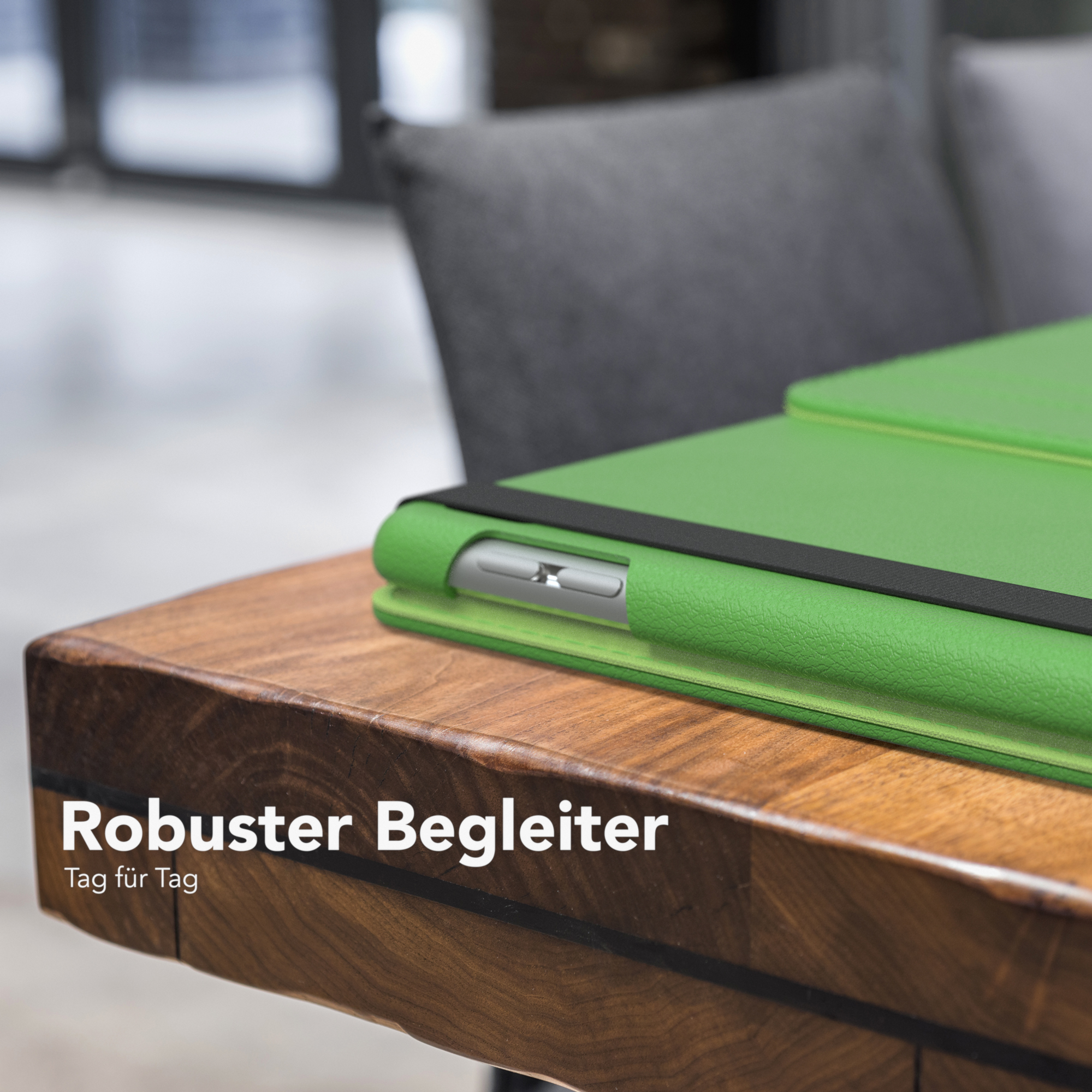 Grünes Tablet in Hülle auf Holztisch. Text: 'Robuster Begleiter'.
