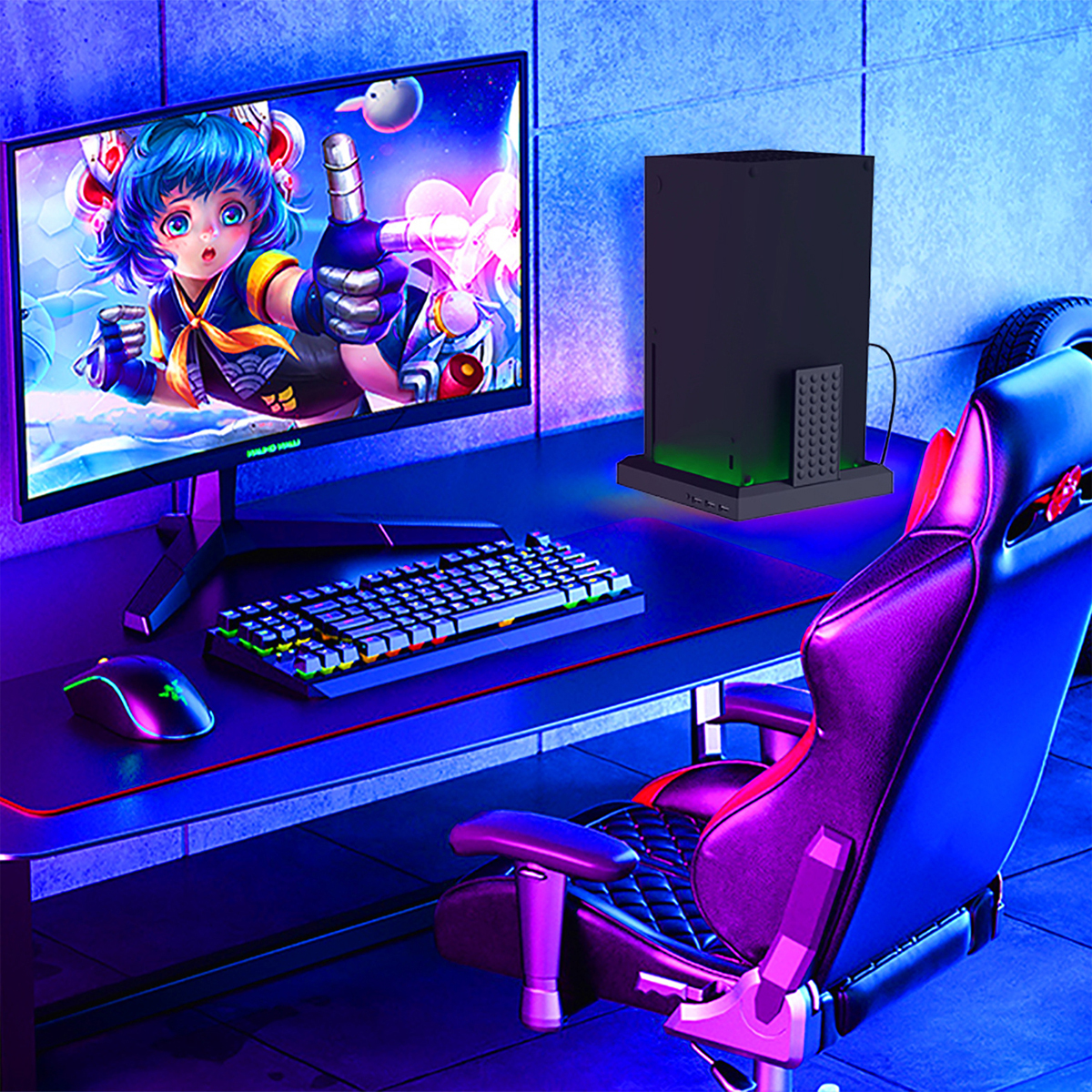 Ein Gaming-Setup. Ein Monitor, eine Tastatur, eine Maus und ein Gaming-Stuhl sind sichtbar.