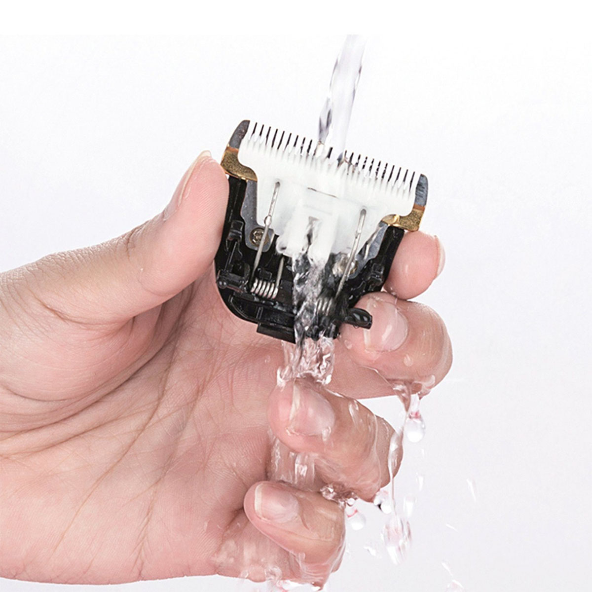 Eine Hand, die einen Rasiererkopf unter fließendes Wasser hält. Klingen sind sichtbar und sauber.