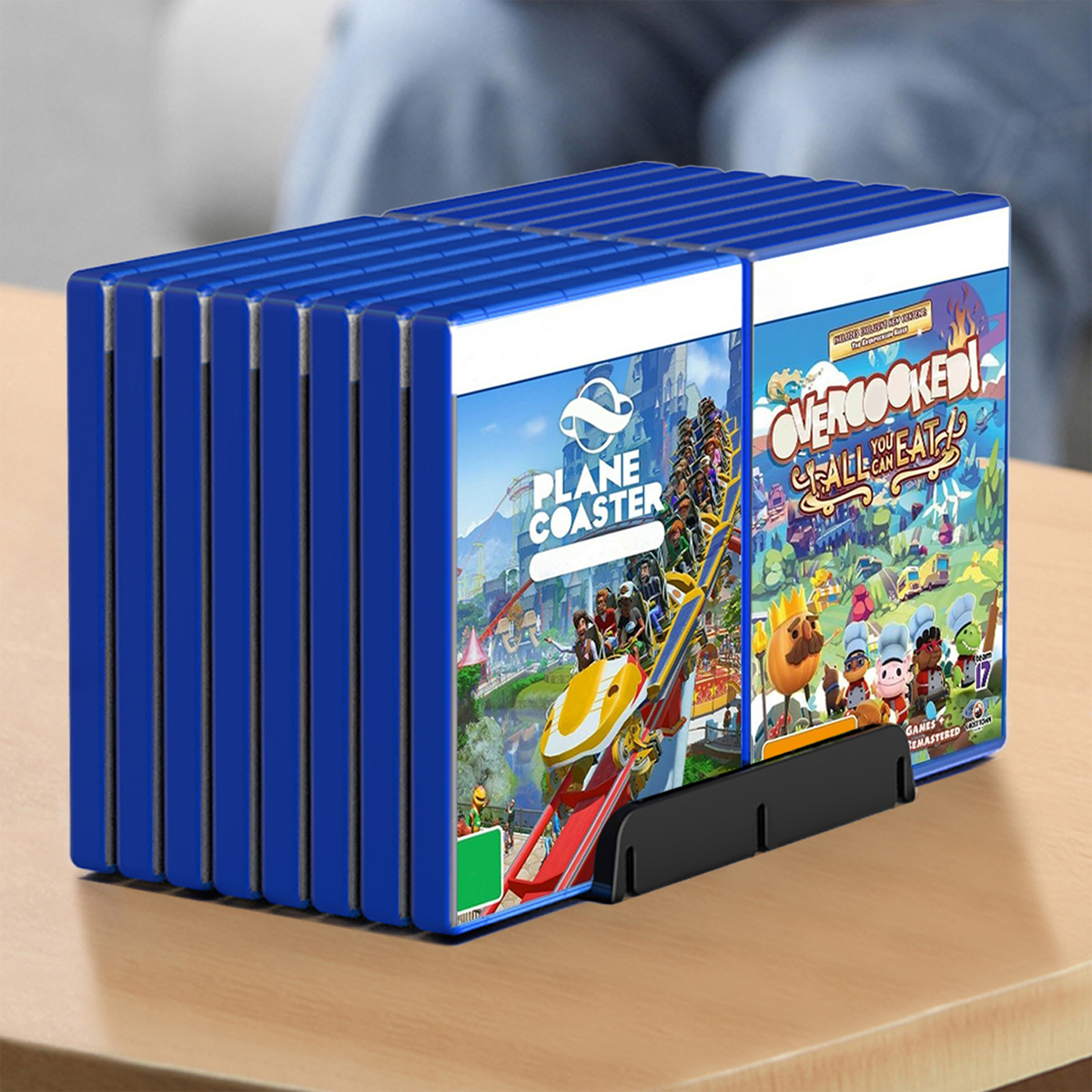 Stapel blauer Spielhüllen mit sichtbaren Spielcovern, auf einem Holztisch.