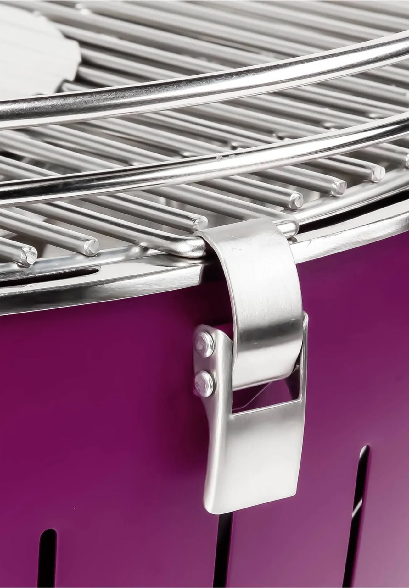 Zbliżenie fioletowego grilla ze srebrnym uchwytem i otworami wentylacyjnymi.