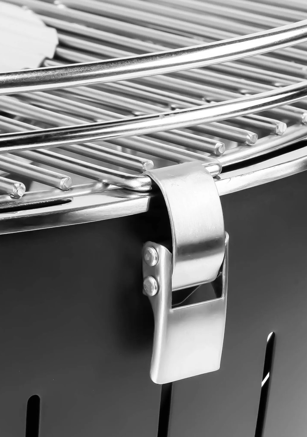 Zbliżenie grilla BBQ, pokazujące uchwyt i część grilla.