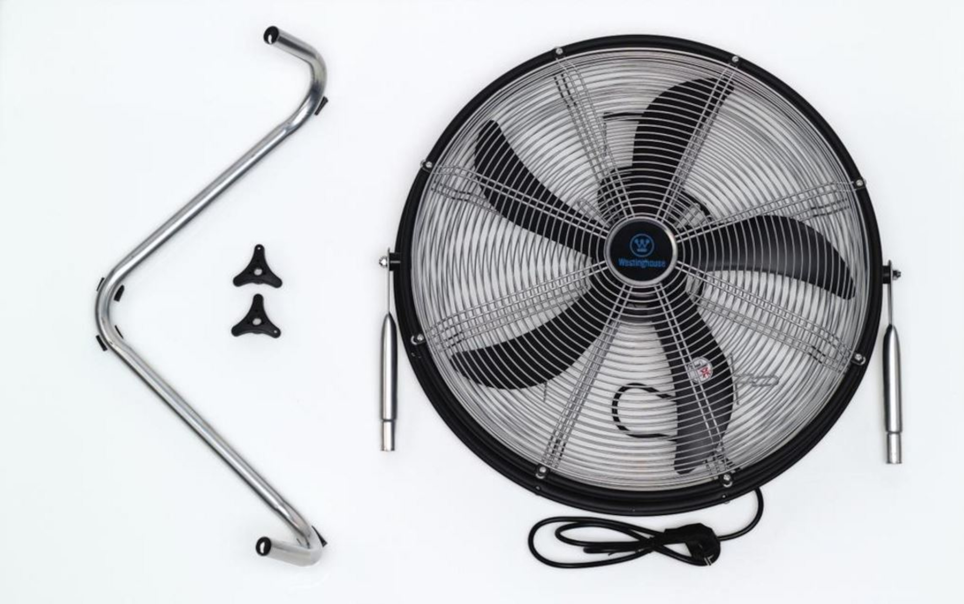 Un ventilatore industriale rotondo, smontato, con parti del supporto e un cavo su sfondo bianco.