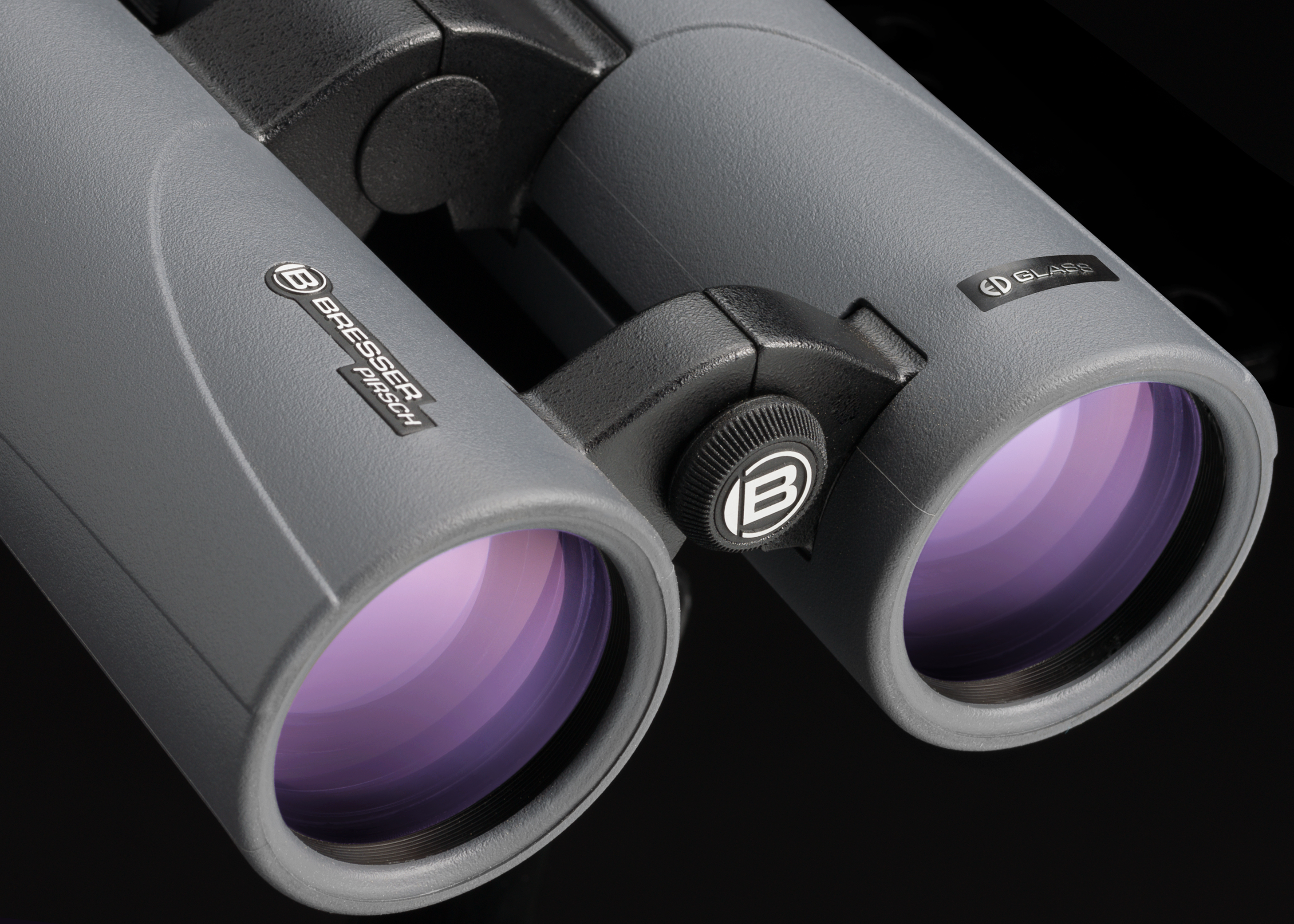 Graues Fernglas mit violetten Linsen. Bresser Pirsch steht auf der Seite.