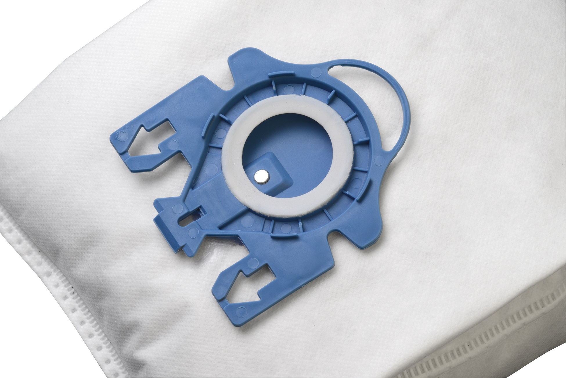 Weißer Staubsaugerbeutel mit blauem Kunststoffaufsatz. Er hat ein Metallteil.