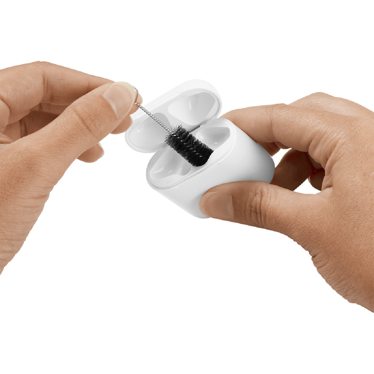 Mani che puliscono una custodia bianca per AirPods con una piccola spazzola. La spazzola è nera.