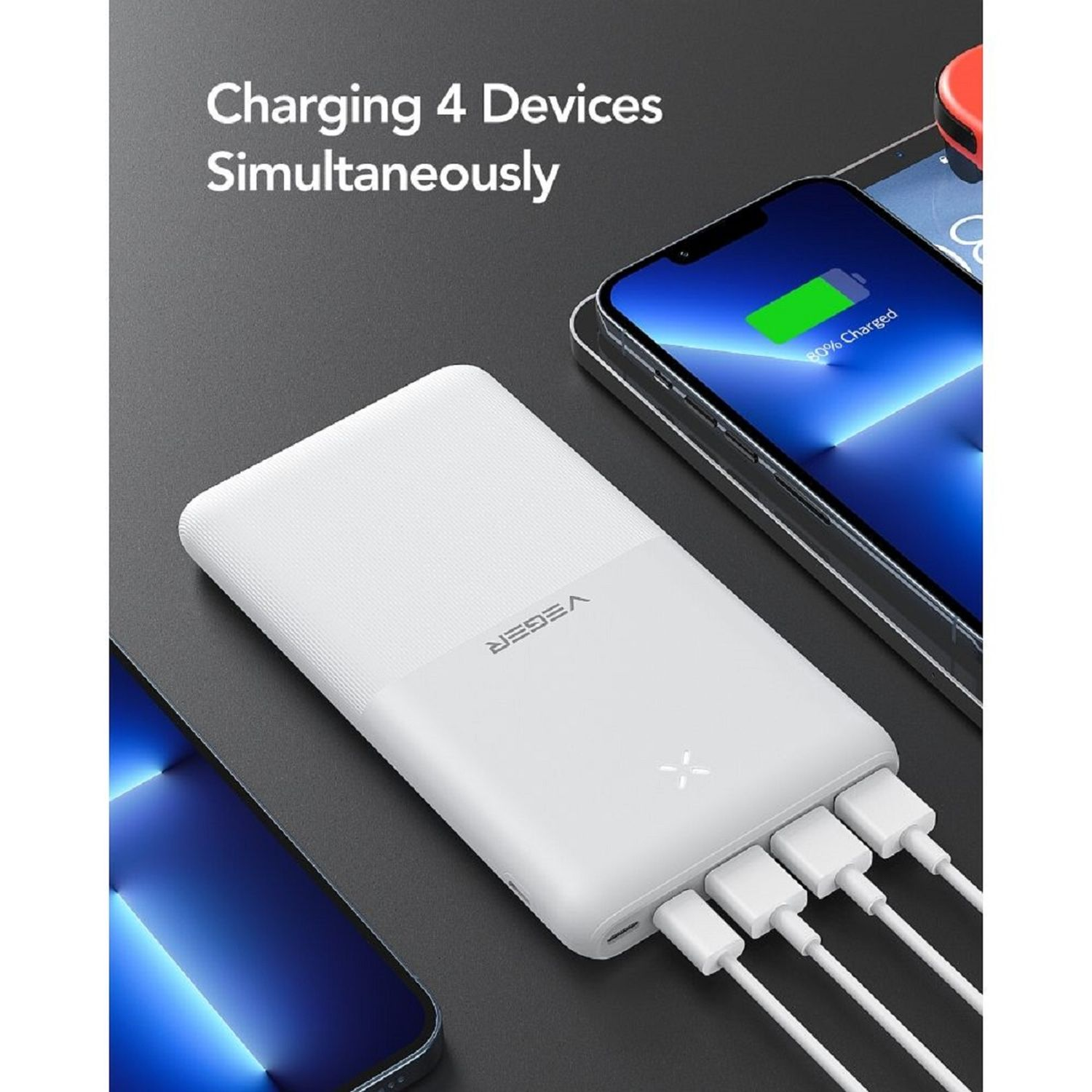 Un power bank bianco che carica quattro dispositivi contemporaneamente. I telefoni sono collegati tramite cavi bianchi.