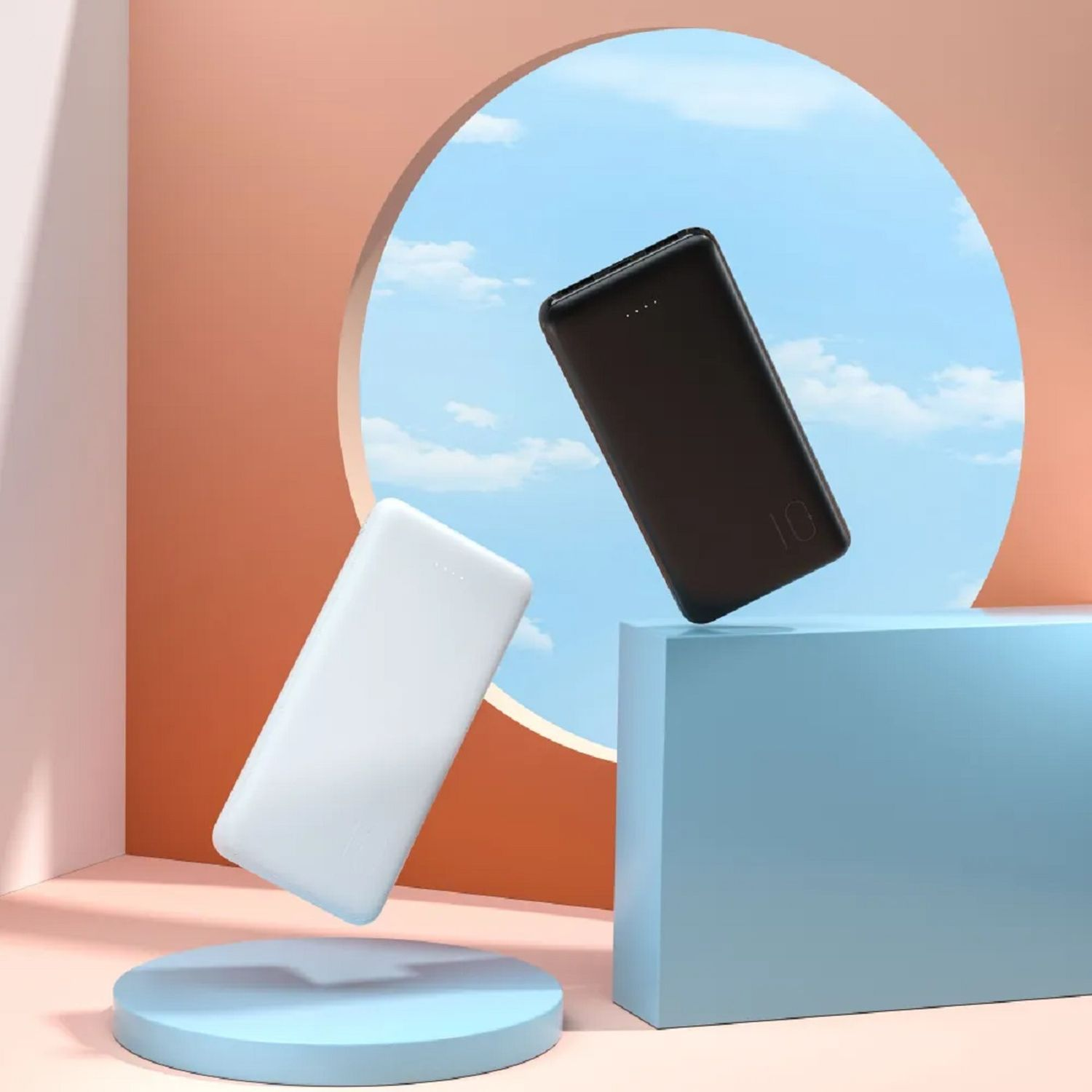 Zwei Powerbanks, eine schwarze und eine weiße, die vor blauem und pfirsichfarbenem Hintergrund schweben.