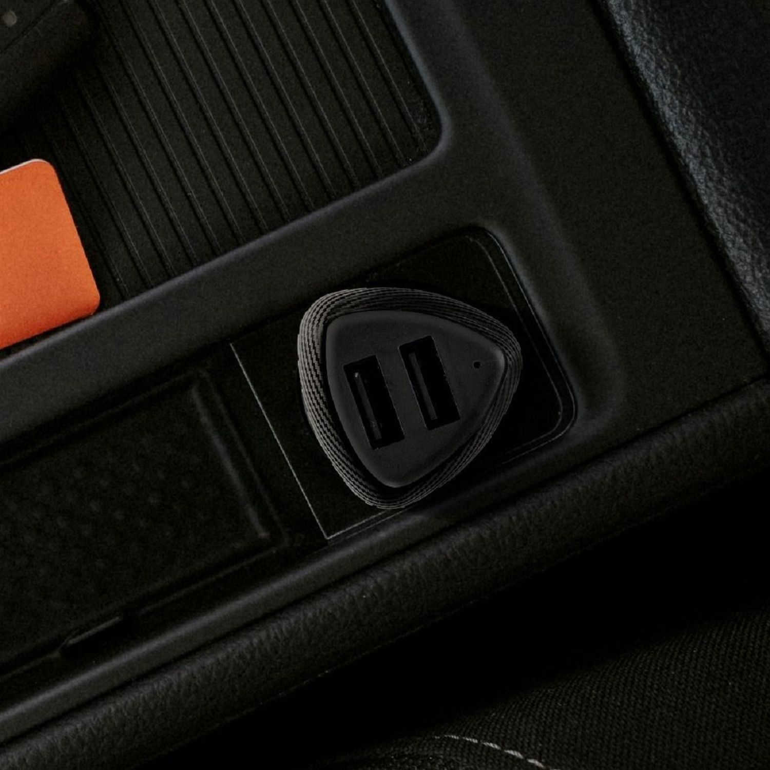 Ein USB-Autoladegerät in der Konsole eines Autos. Schwarz mit zwei USB-Anschlüssen.