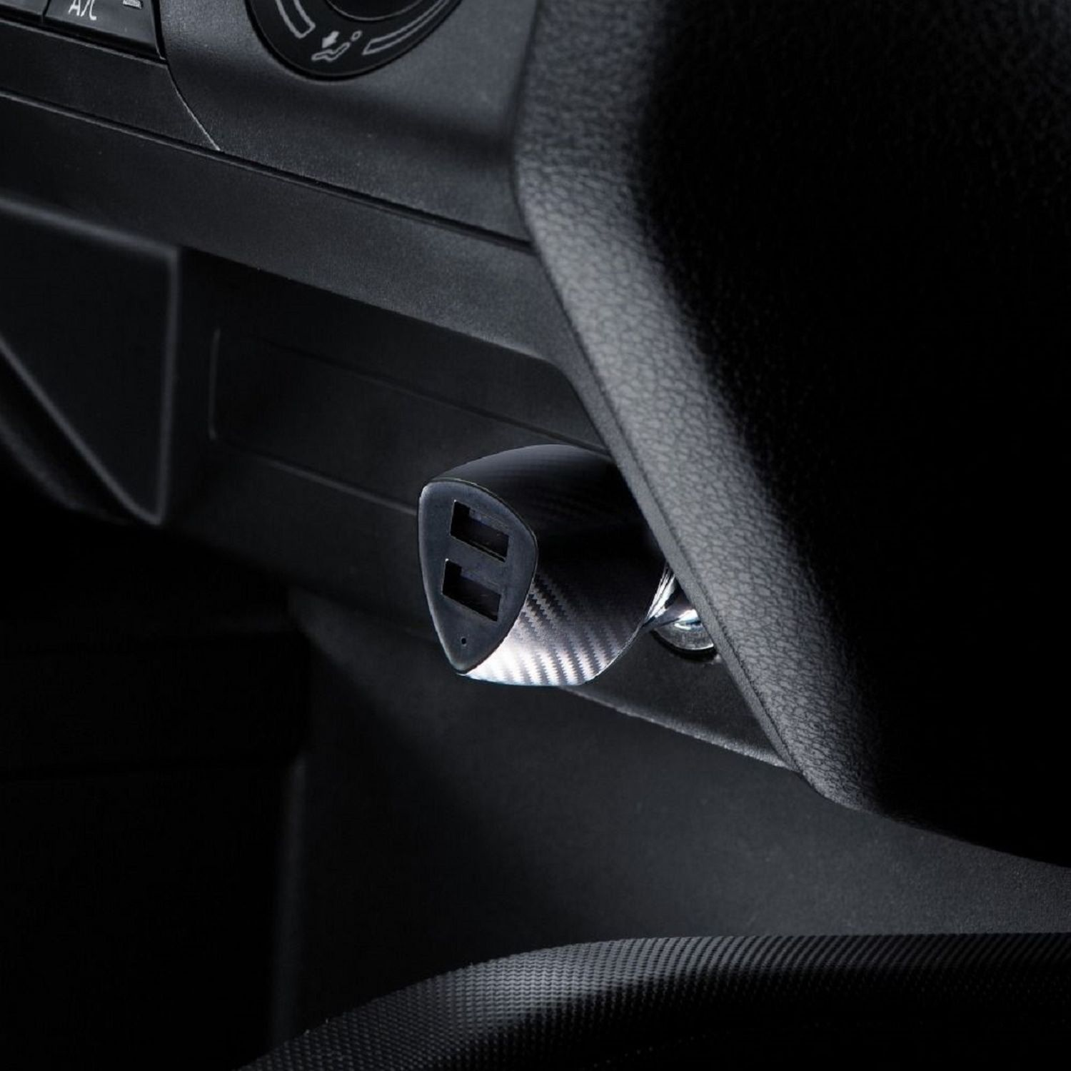 Ein schwarzes Autoladegerät mit USB-Anschlüssen, das in der Konsole eines Autos installiert ist.