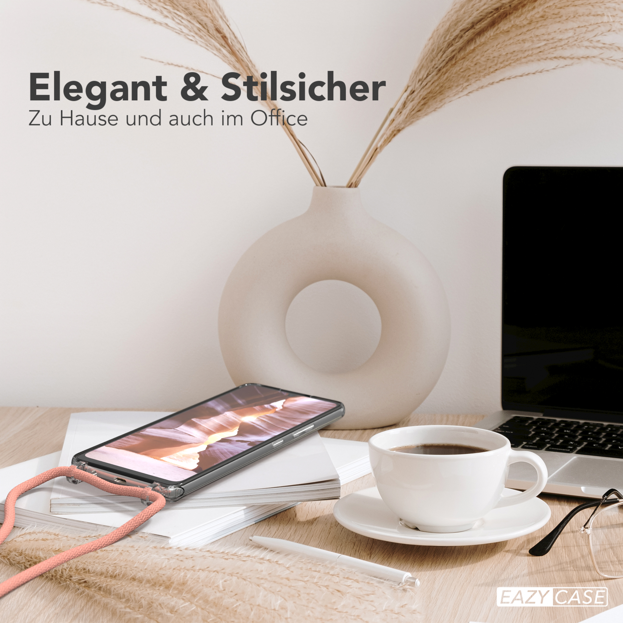 Telefon mit Hülle und Kordel auf einem Schreibtisch mit Laptop und Kaffeetasse.