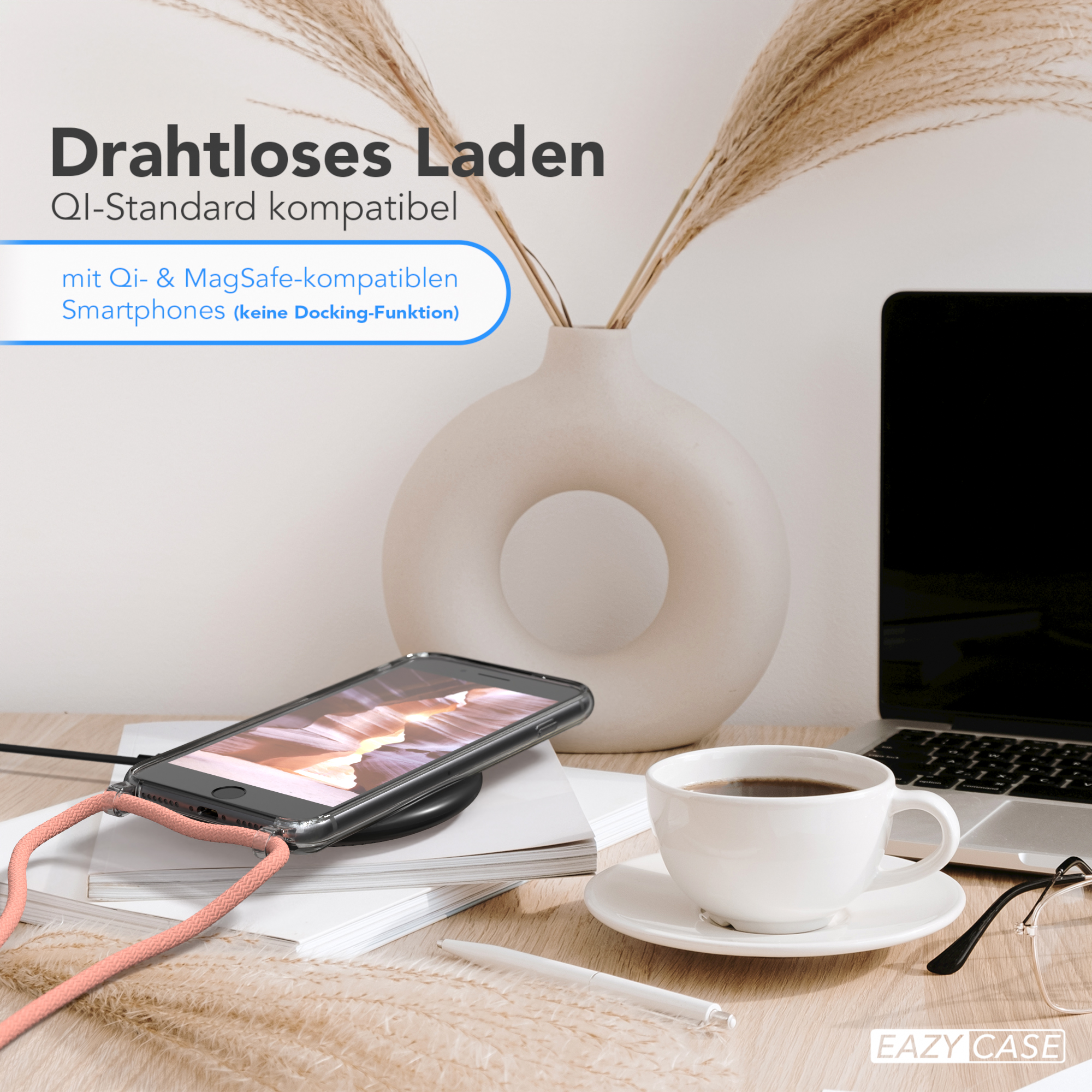 Ein Telefon auf einem kabellosen Ladegerät. Auf dem Schreibtisch stehen eine Kaffeetasse und ein Notizblock. Weiße Vase und Pflanze.