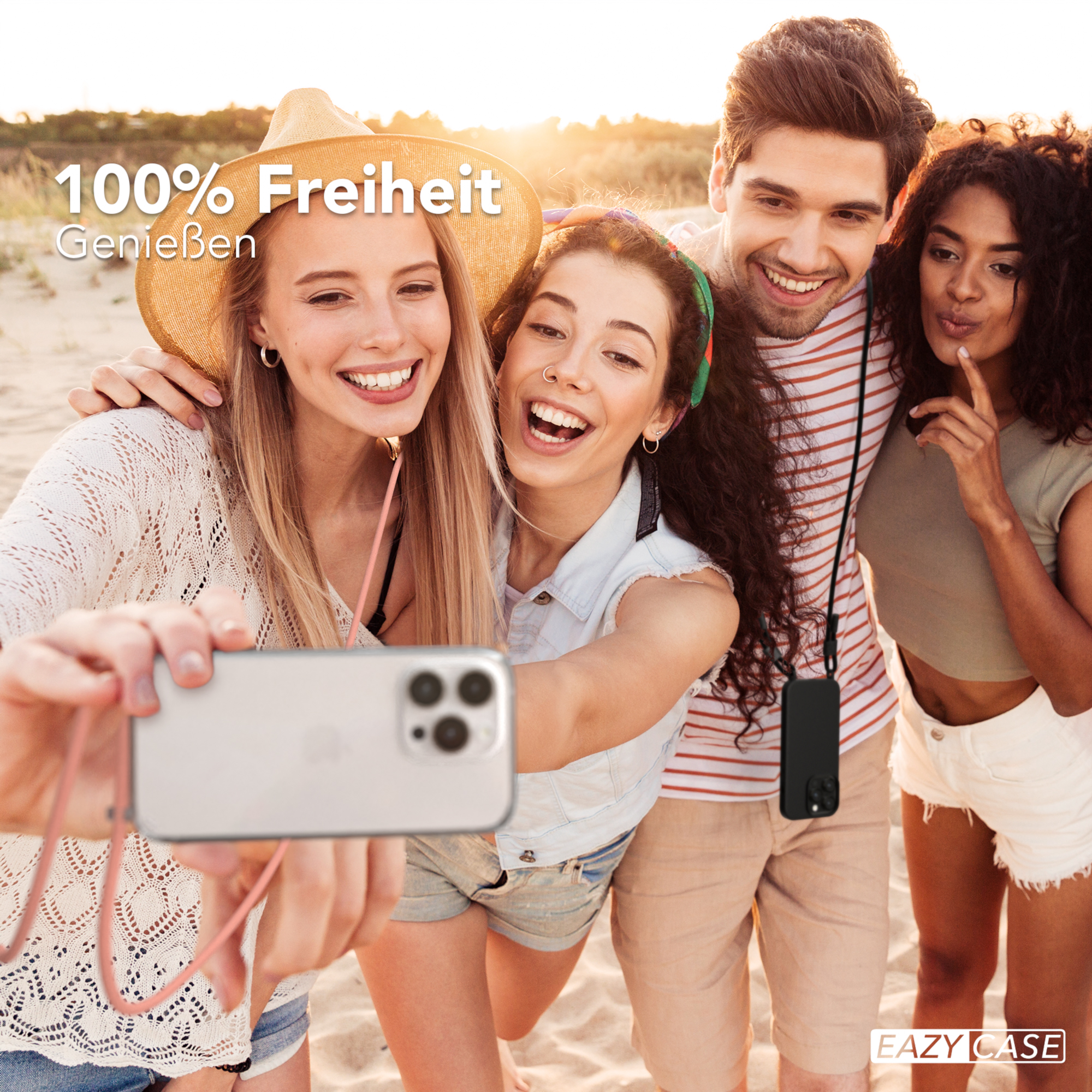 Vier junge Leute machen ein Selfie am Strand. Eine Person hält das Telefon.