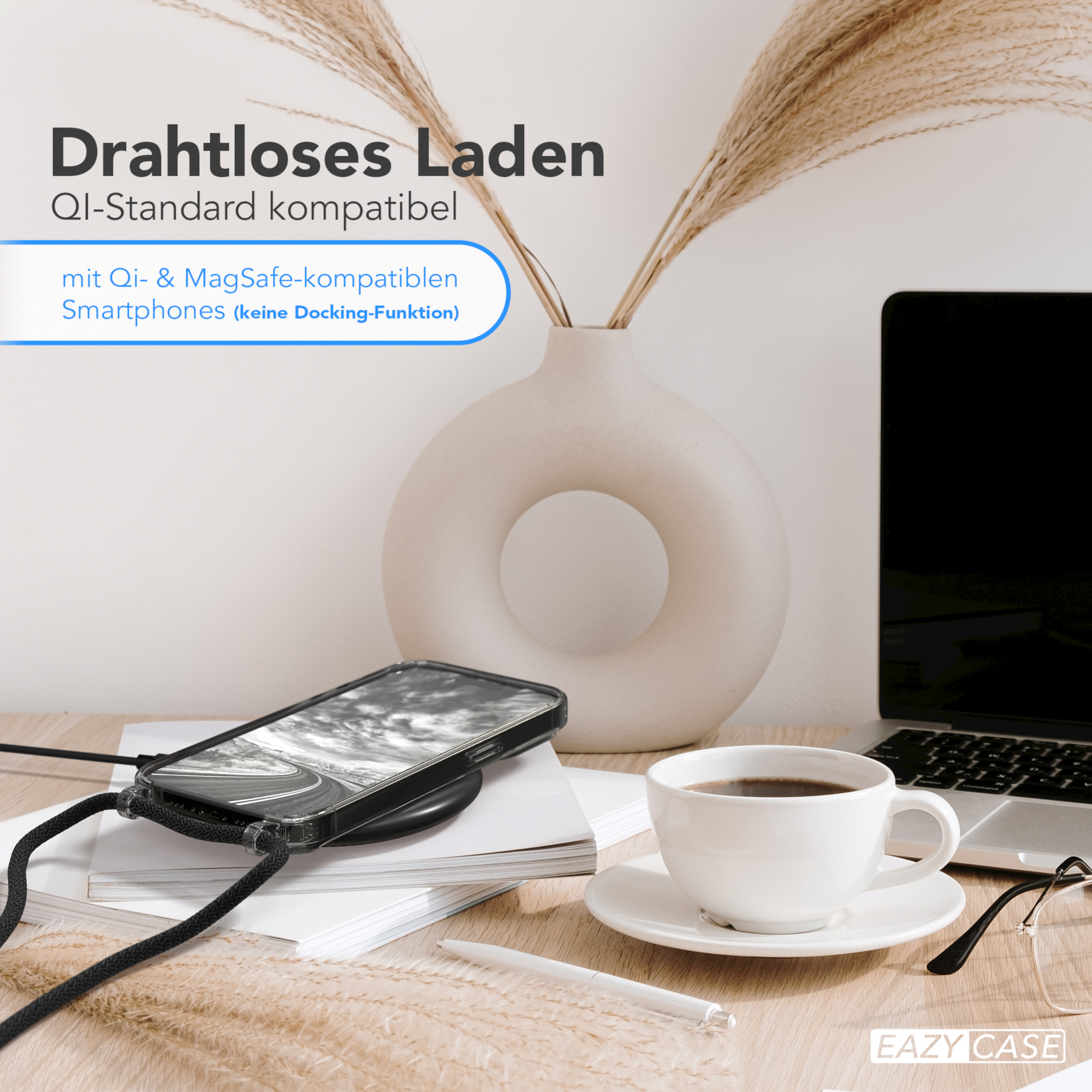 Ein Telefon, das drahtlos auf einem Schreibtisch geladen wird. Eine weiße Tasse, ein Laptop und eine Vase mit Pflanzen sind ebenfalls vorhanden.