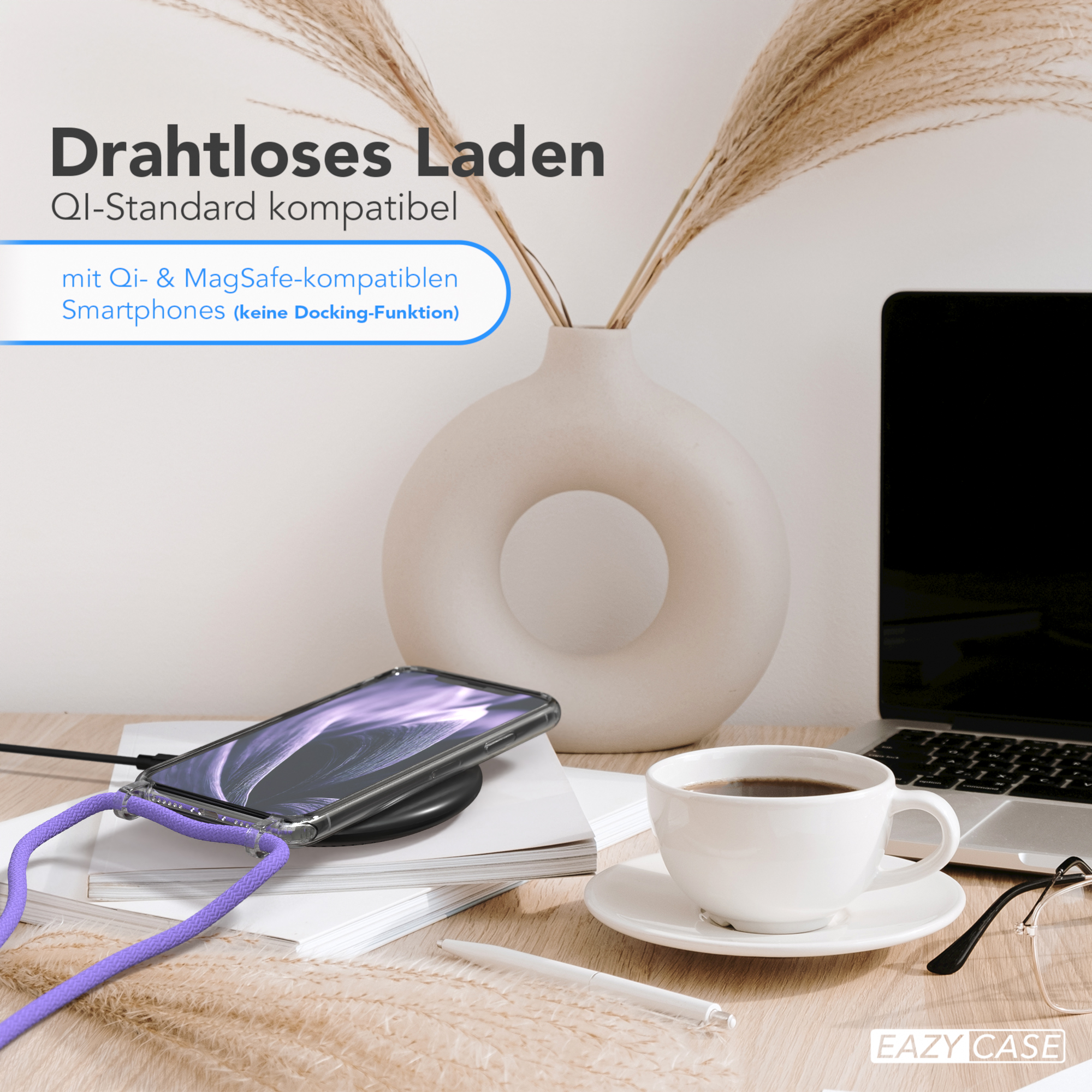 Ein Telefon mit Lanyard auf einem kabellosen Ladegerät, mit einer Kaffeetasse und einem Laptop im Hintergrund.