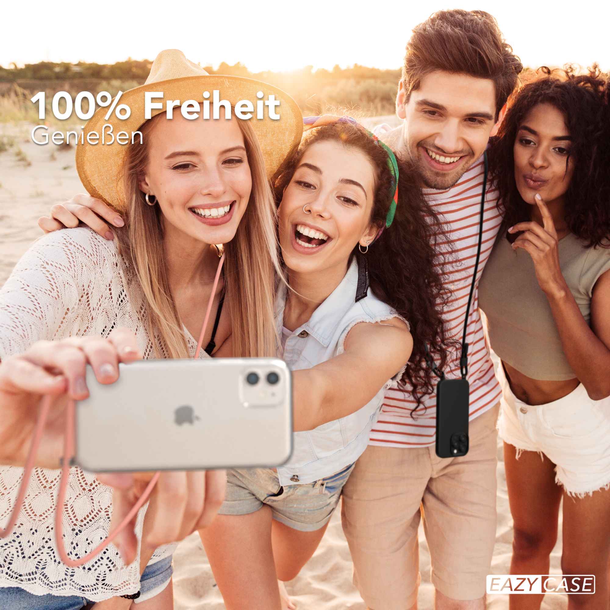 Vier junge Leute machen ein Selfie am Strand. Sie lächeln in die Kamera.