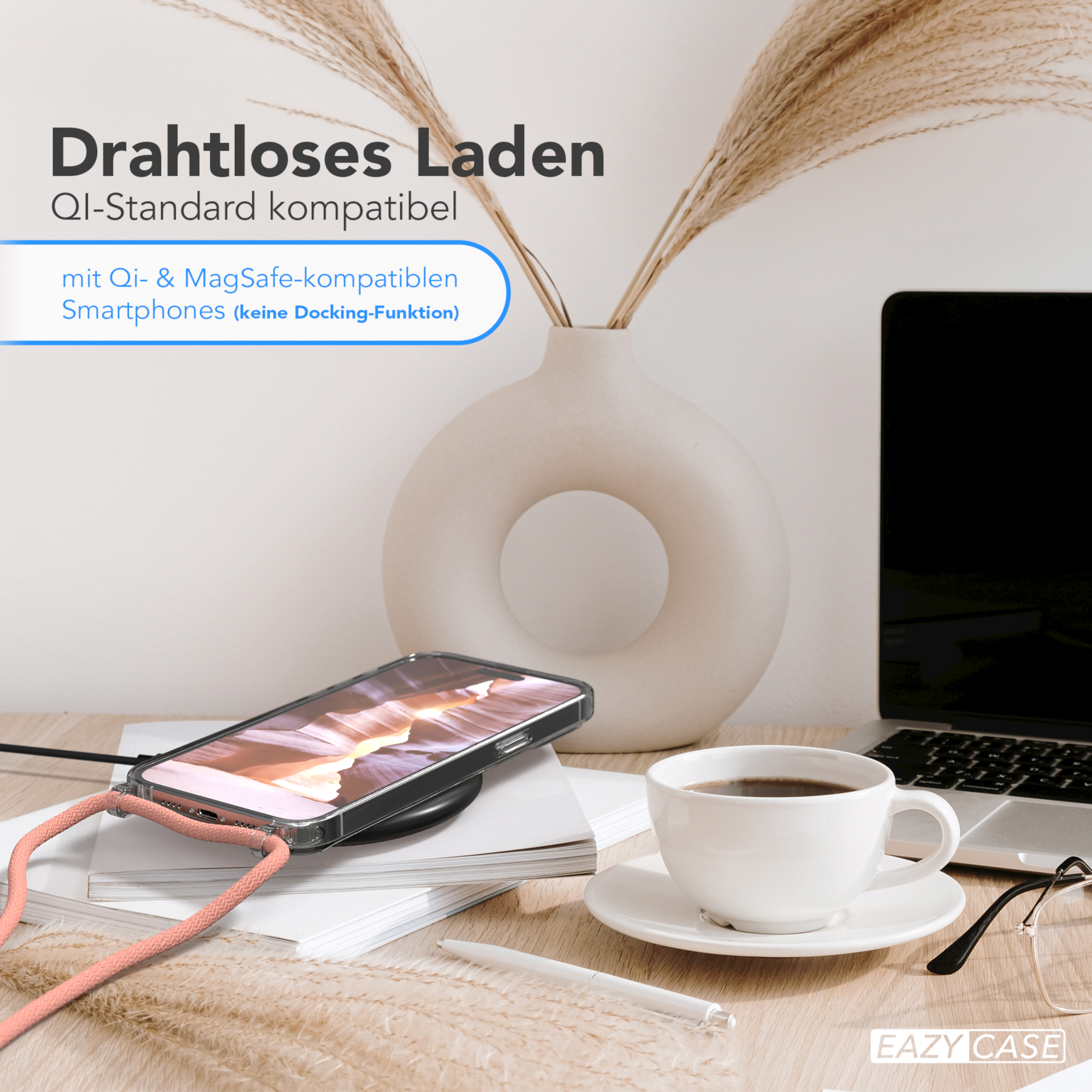 Telefon auf Ladepad mit Zubehör. Kaffeetasse, Brille und Vase vorhanden.