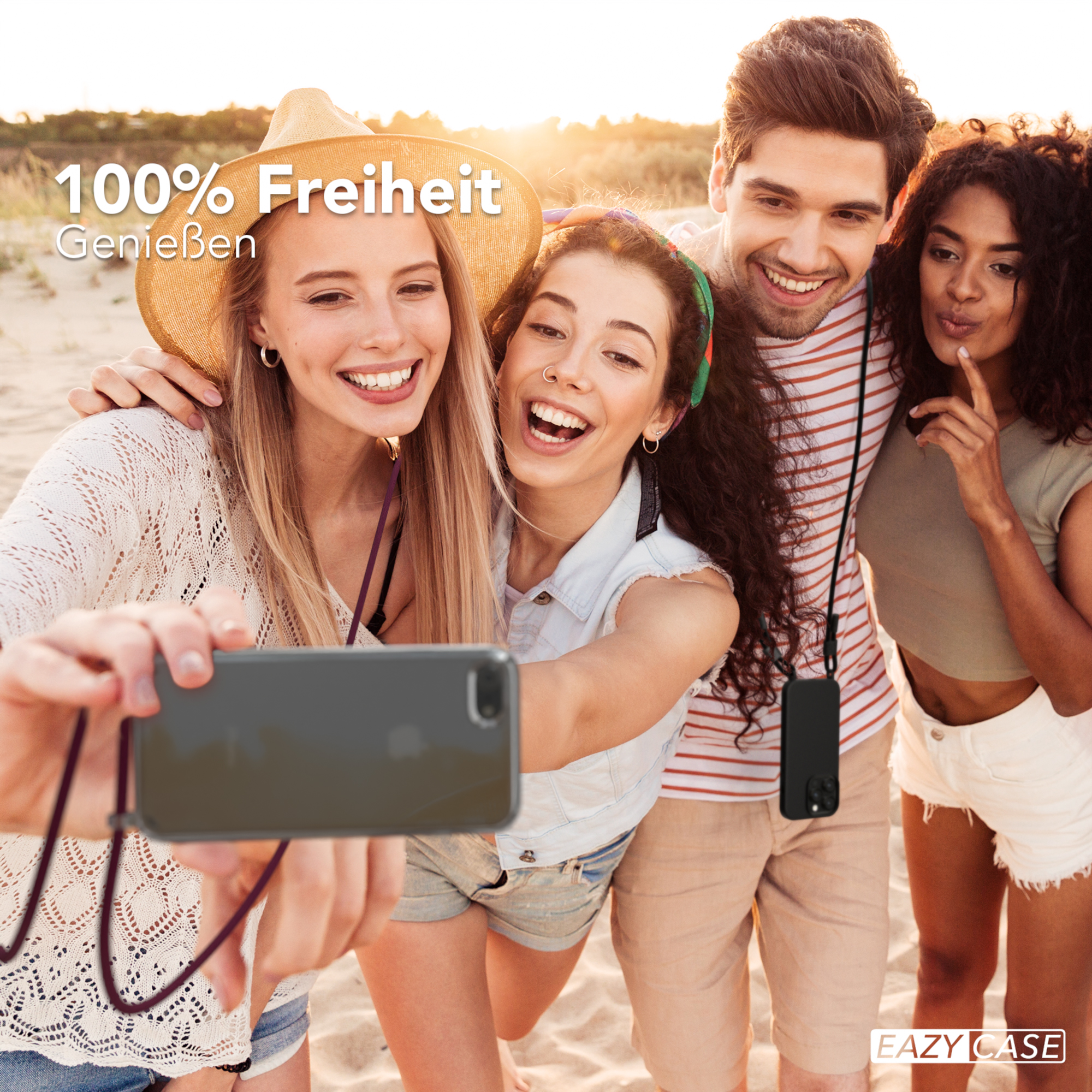 Vier junge Leute machen ein Selfie am Strand. Sie lächeln in die Kamera.