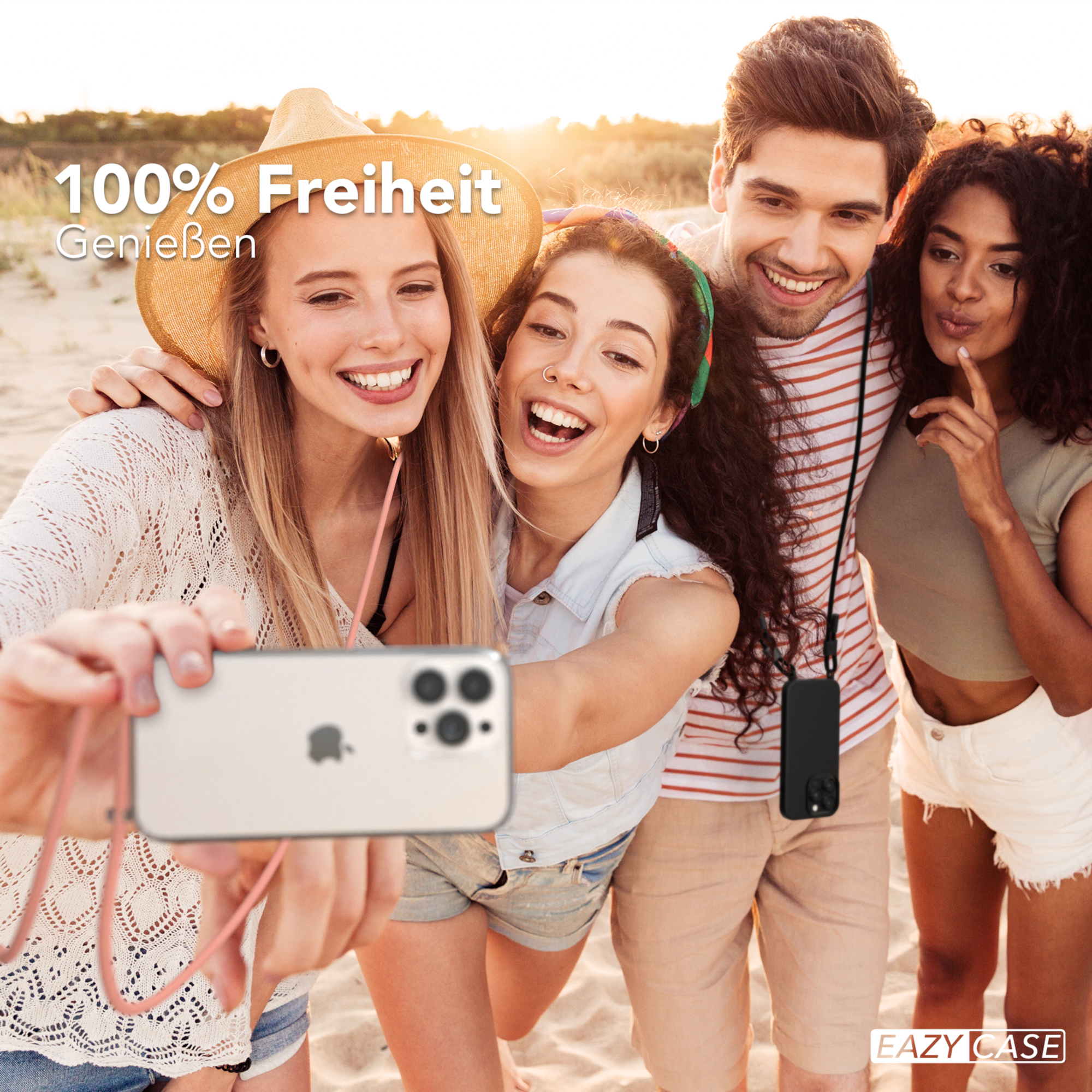 Vier Personen machen ein Selfie am Strand. Sie lächeln und halten ein Telefon mit rosa Band.