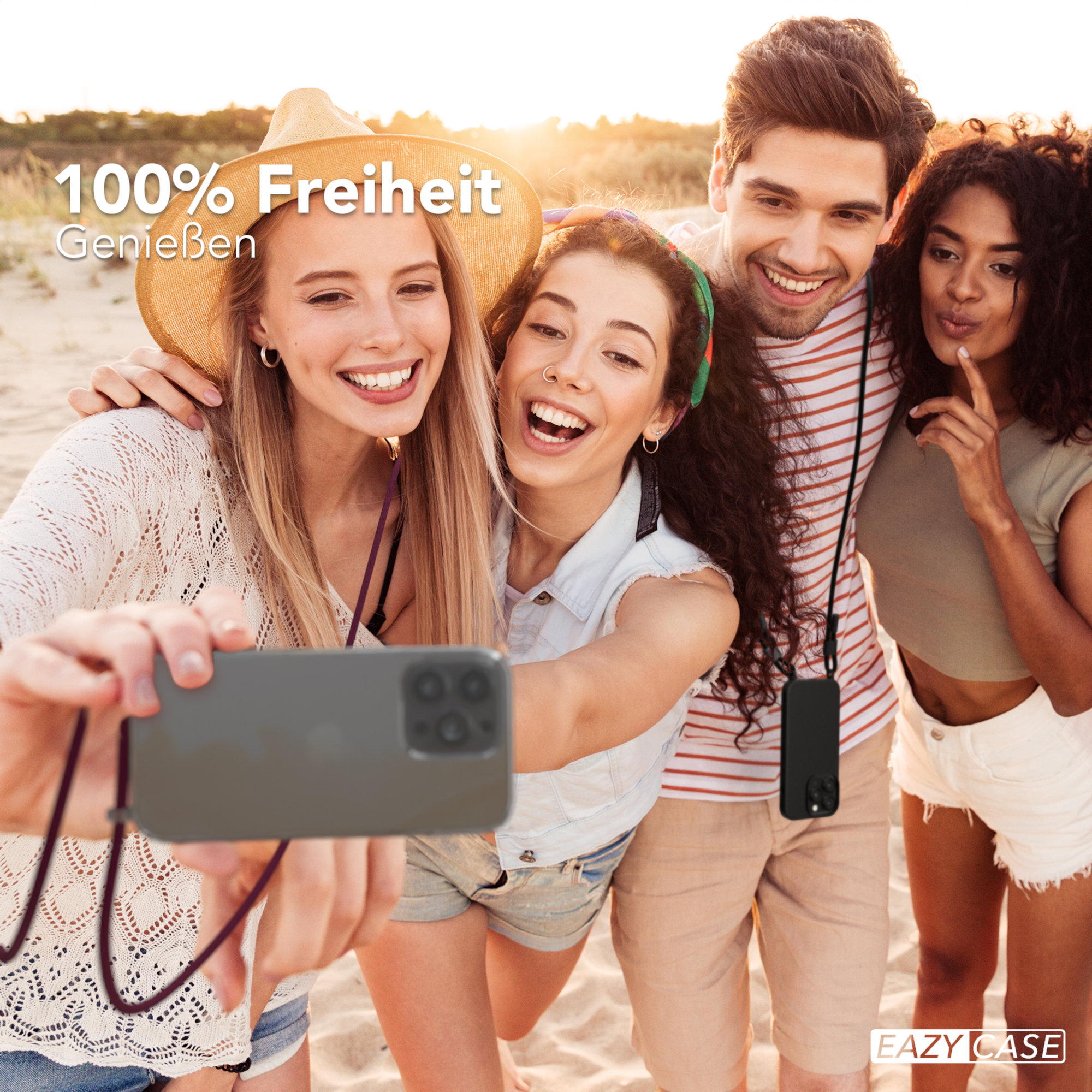 Vier Personen machen ein Selfie am Strand, halten ein Telefon mit Umhängeband.