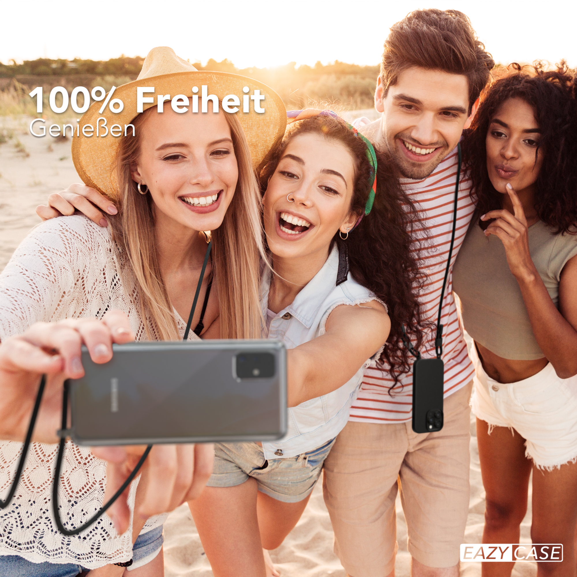 Vier Personen machen ein Selfie am Strand mit einem Telefon an einem Lanyard, lächeln und lachen.