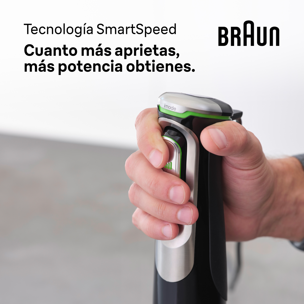 Ręka trzyma czarno-srebrny blender ręczny Braun. Rozmyte tło. Zbliżenie.