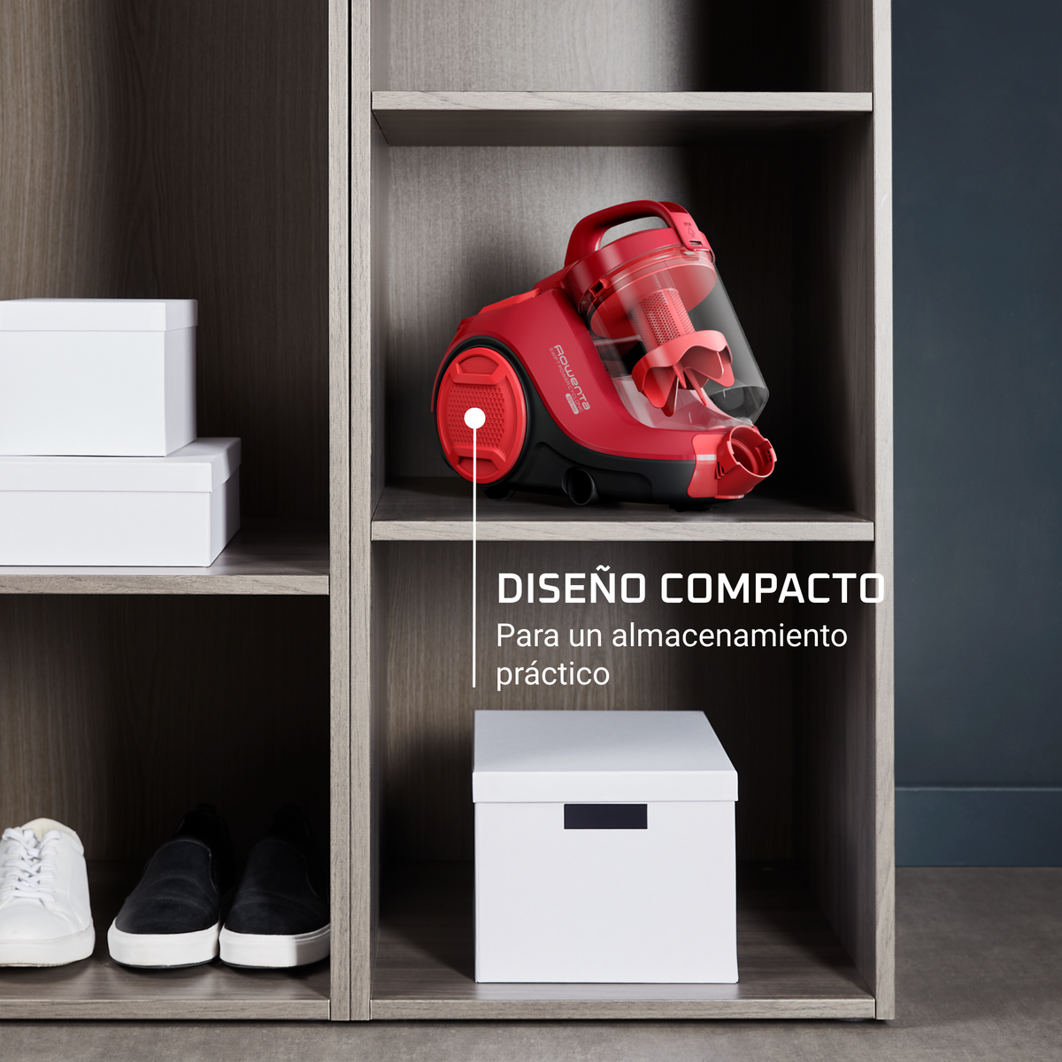 Czerwony odkurzacz w szafce. Szafka ma półki z białymi pudełkami i butami.