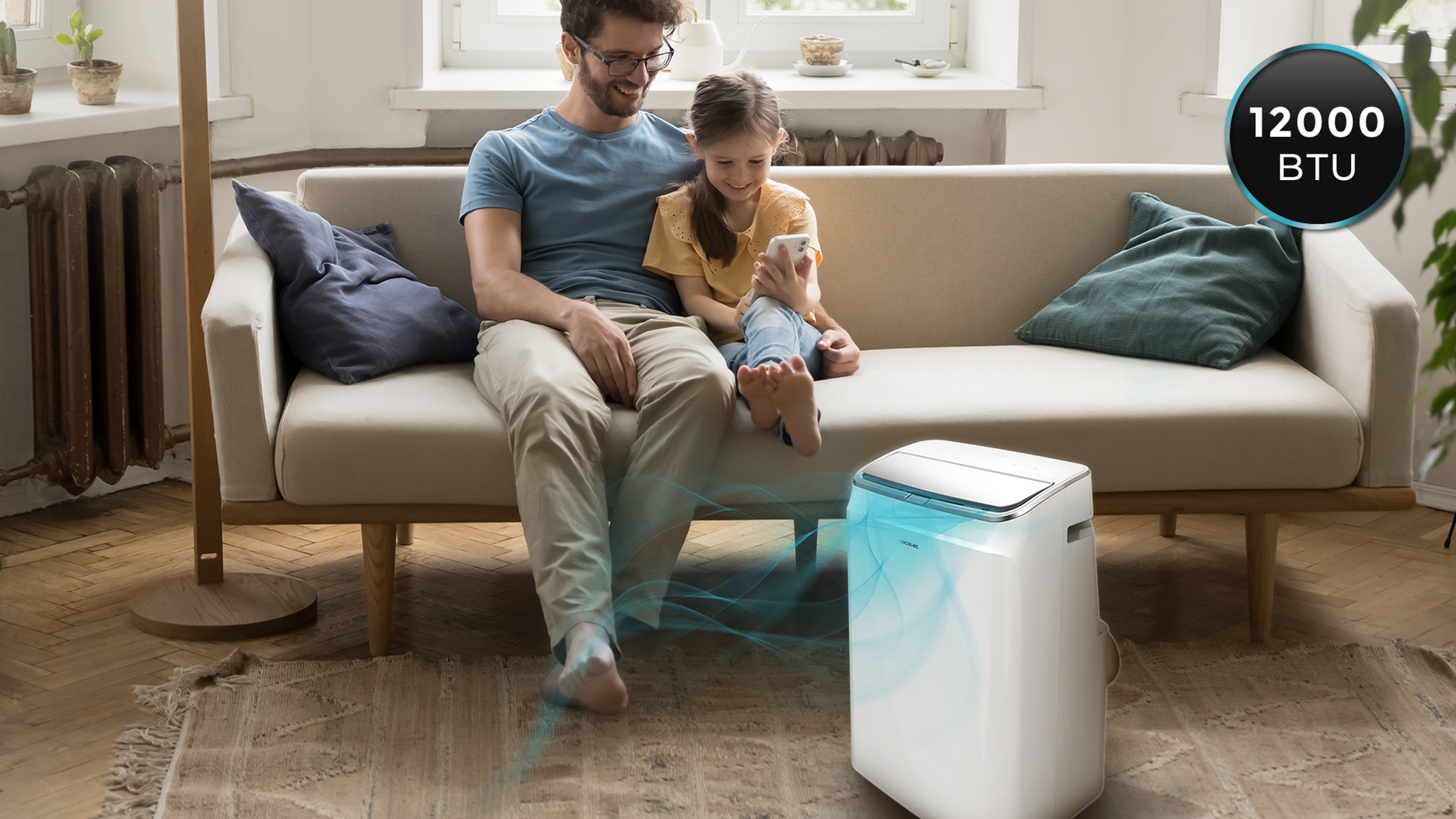 Biały klimatyzator z dzieckiem i mężczyzną siedzącymi na kanapie, z etykietą 12000 BTU.