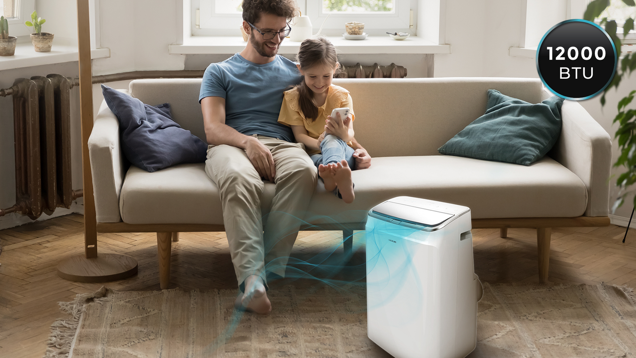 Mężczyzna i dziewczynka na sofie z klimatyzatorem. Etykieta 12000 BTU. Drewniana podłoga.