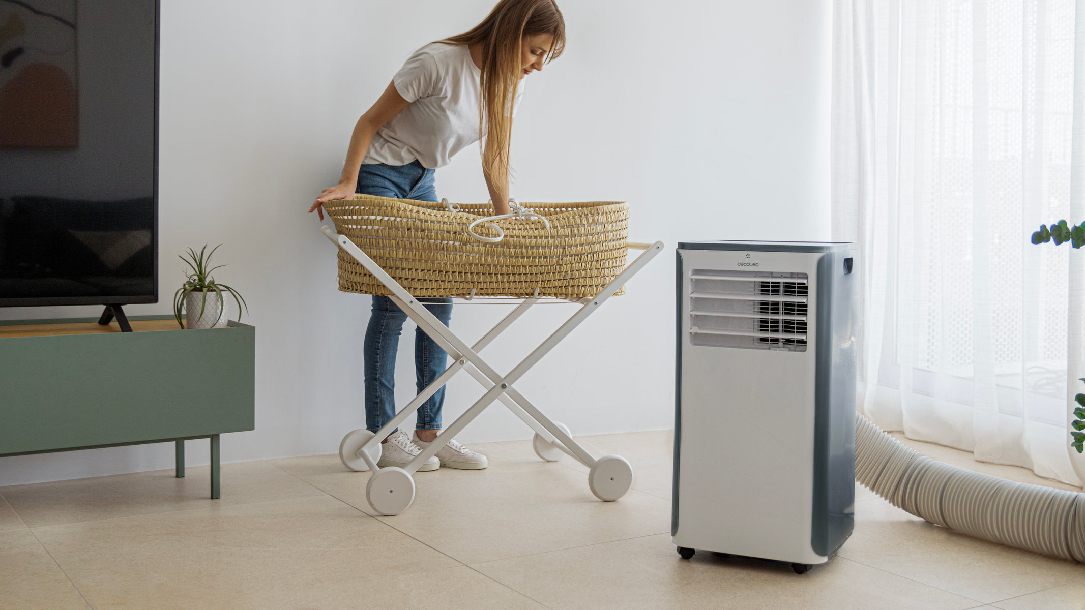 Kobieta i przenośny klimatyzator. Kładzie kosz na stojaku.