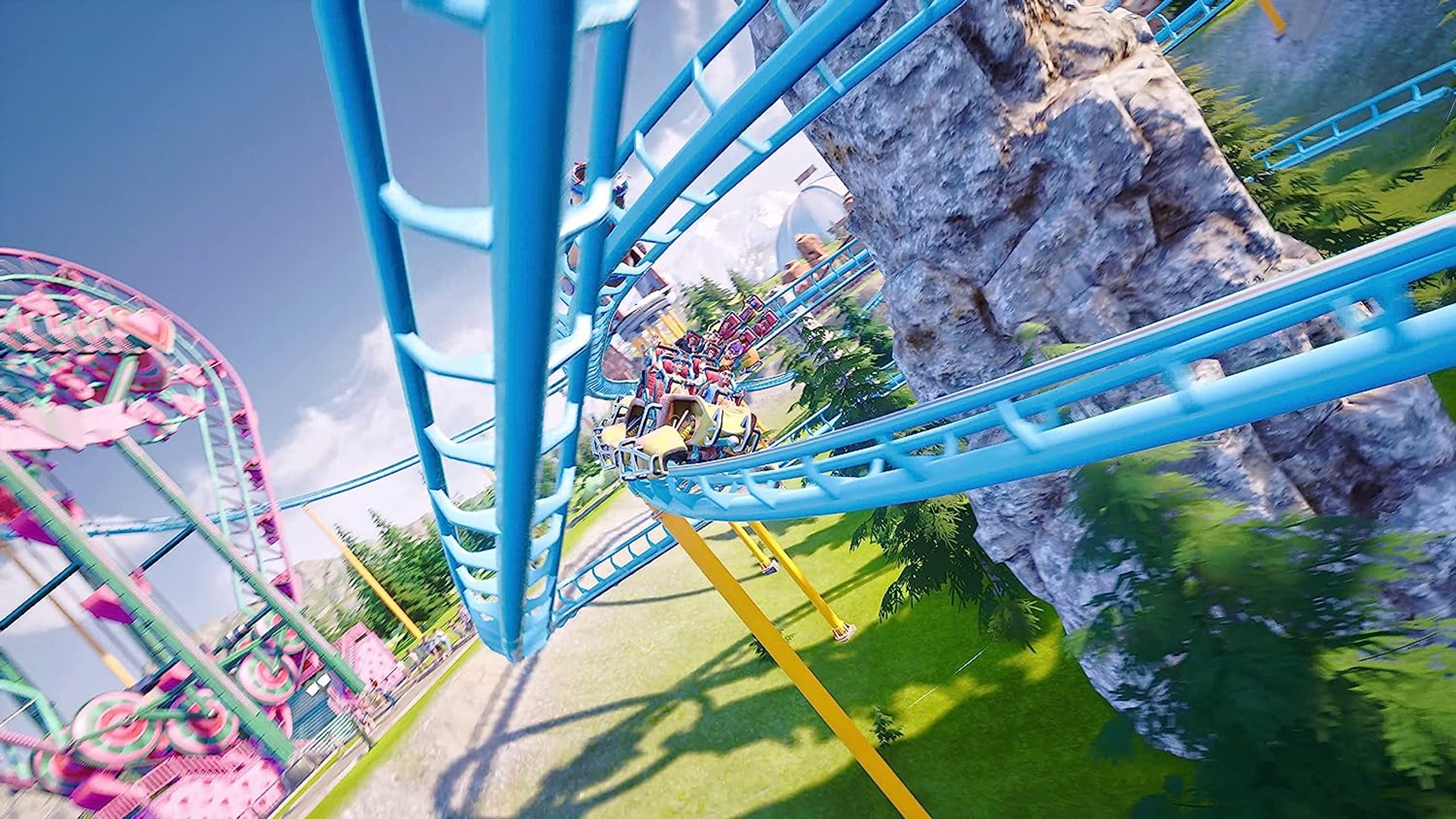 Kolejka górska na torze z ludźmi, diabelskim młynem i zielonym otoczeniem.