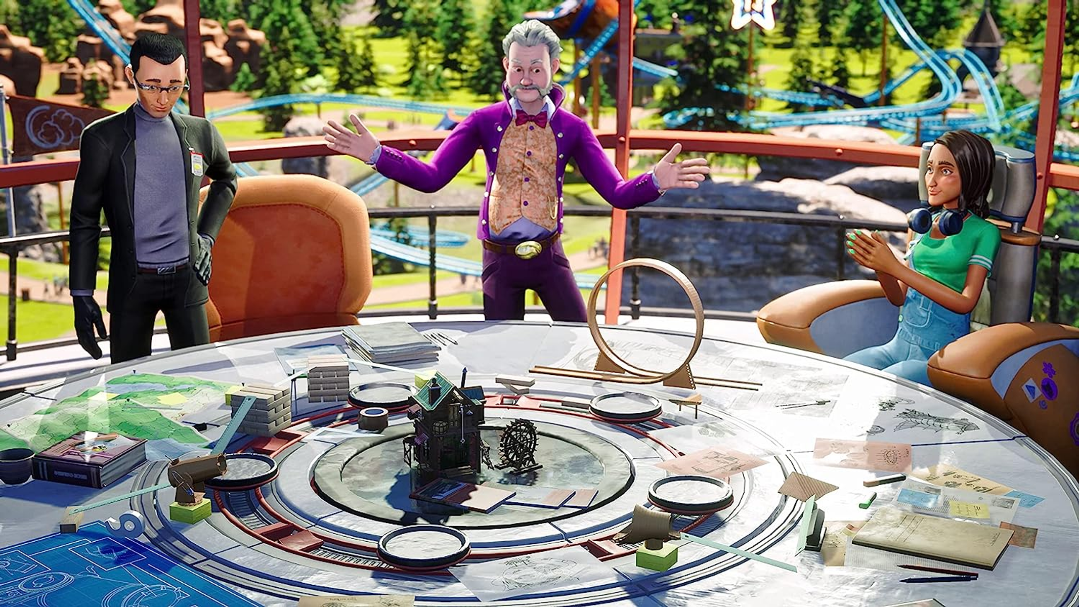 Trzy osoby w pokoju. Mężczyzna w fioletowym garniturze gestykuluje. Kobieta siedzi. Stół z modelami.