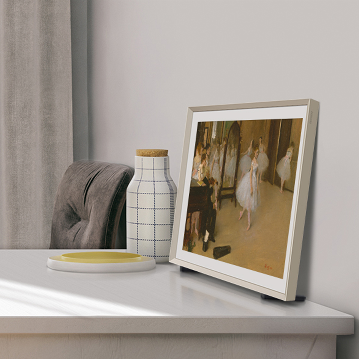 Dzieło sztuki na białym stole. Obraz w ramie i dekoracyjny wazon z żółtą tacą.