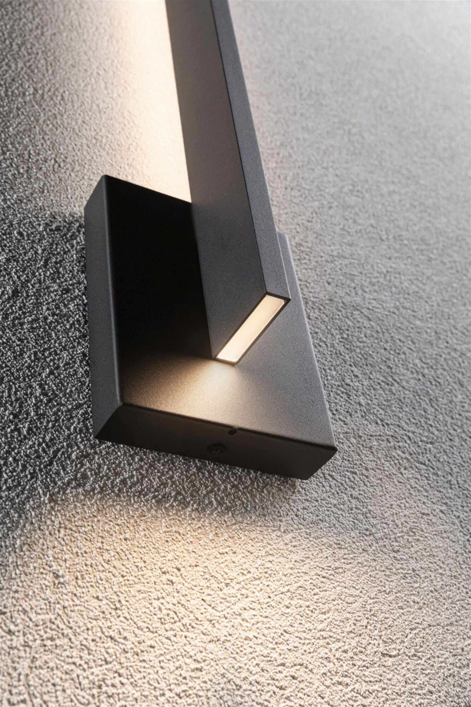 Czarna lampa ścienna ze światłem świecącym w dół.