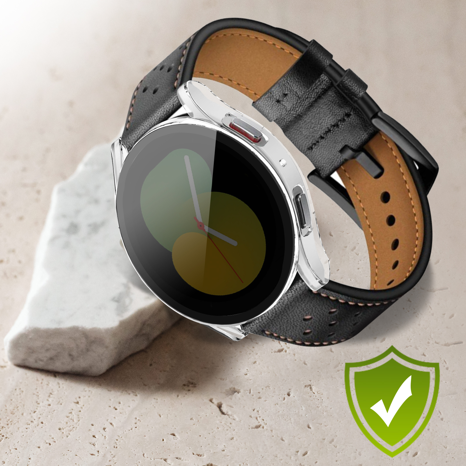 Eine schwarze Leder-Smartwatch mit silbernem Rahmen und braunem Lederarmband auf Stein, mit einem Häkchen.