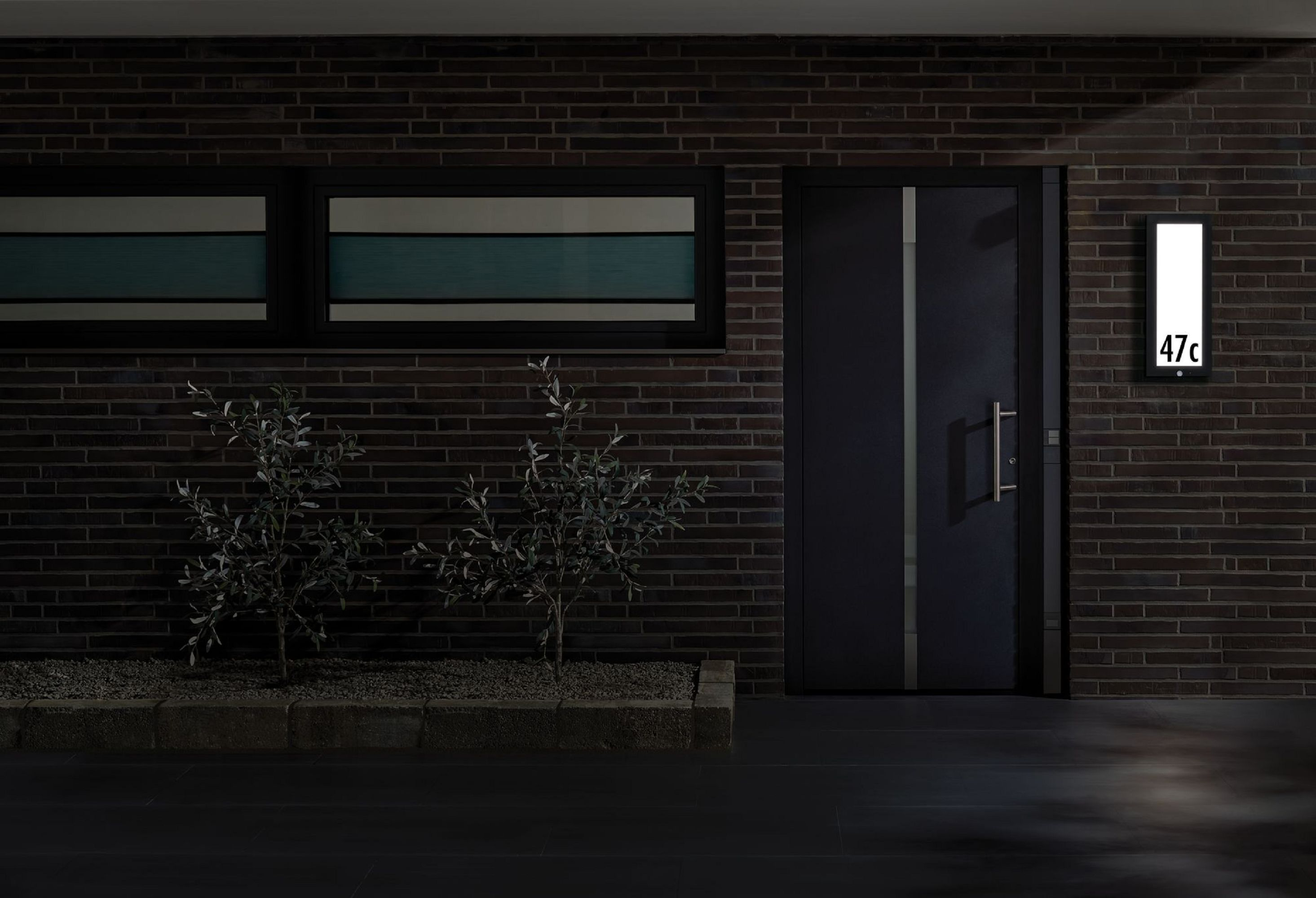 Nocna scena nowoczesnego domu z drzwiami i światłem z numerem 47c.